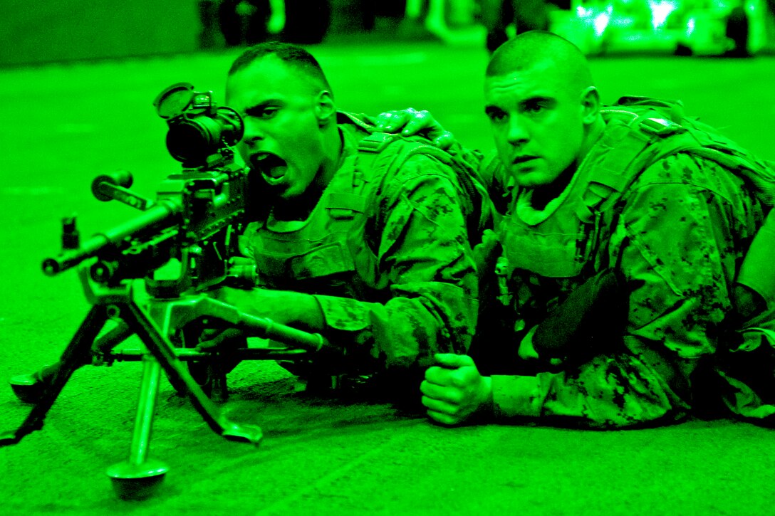 As seen through a night-vision device, Marine Corps Lance Cpl. Erain Abreu, left, aims a 240B light machine gun while Pfc. Zakary Mitchell looks on during a weapons familiarization exercise in the hangar bay of the amphibious assault ship USS Wasp in the Atlantic Ocean, Feb. 4, 2012. Abreu and Mitchell are assigned to the 2nd Marine Expeditionary Brigade. The Wasp is participating in Exercise Bold Alligator 2012.  
