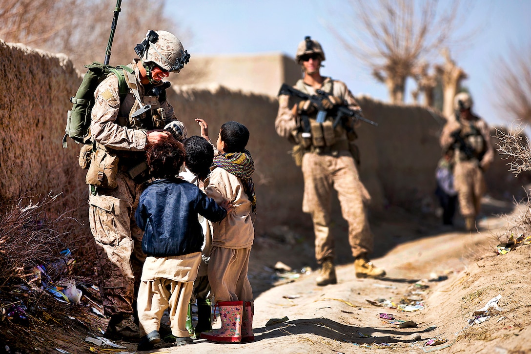 U.S. Marine Lance Cpl. Galen Murphy-Fahlgren hands candy to Afghan children during a security patrol with Afghan Border Police in Helmand province, Afghanistan, Jan. 30, 2012. Murphy-Fahlgren is an anti-tank missileman assigned to Weapons Company, 3rd Battalion, 3rd Marine Regiment. In the southern Garmsir district, an area with a history of tribal conflict, the growing Afghan force has deepened its roots and established governance through Marine mentors. 
