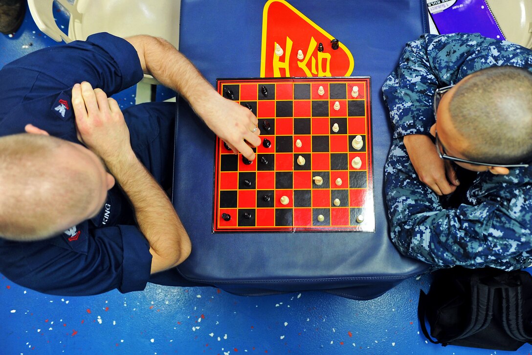 U.S. Navy Petty Officer 2nd Class Isaiah King, left, makes a move in a chess match with Seaman Jeffrey Delapena on the mess decks aboard the amphibious assault ship USS Makin Island in the Arabian Sea, Jan. 26, 2012. King is an air-traffic controller and Delapena is an engineman fireman. The Makin Island and Marines assigned to the 11th Marine Expeditionary Unit are supporting maritime security operations and theater security cooperation efforts in the U.S. 5th Fleet area of responsibility.  
