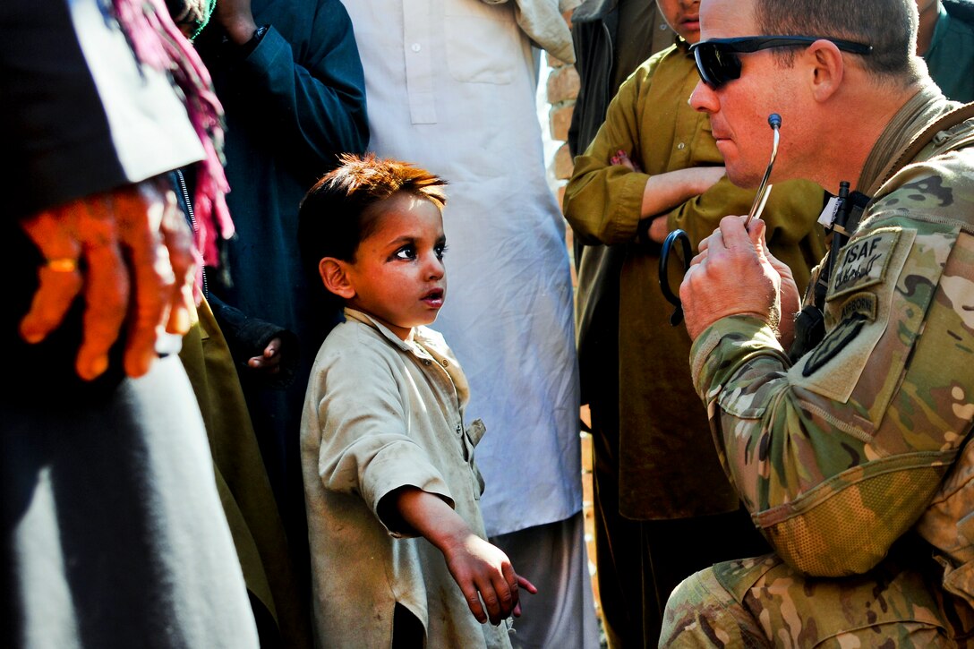 U.S. Army Spc. Joe Kunsch performs medical checks on village children during a combat patrol in Khowst province, Afghanistan, Jan. 25, 2012. Kunsch is a medic assigned to 2nd Battalion, 377th Parachute Field Artillery Regiment.  
