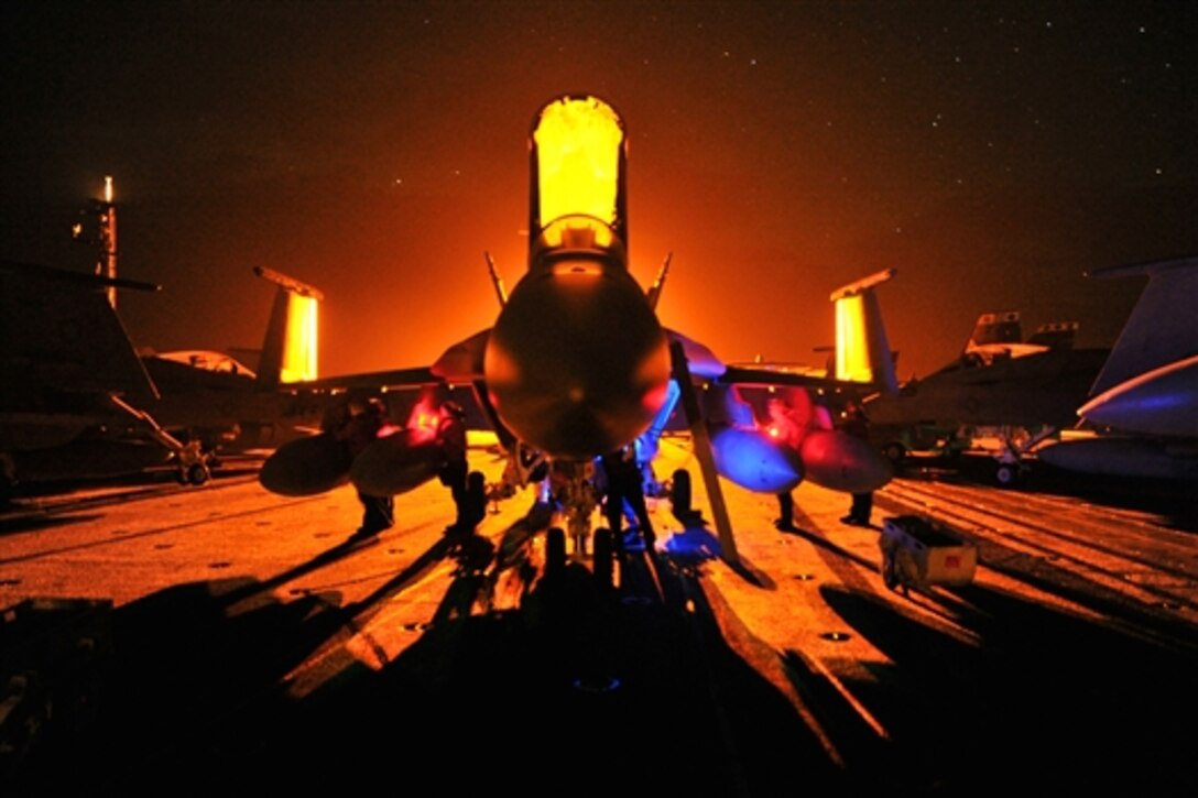 U.S. sailors conduct maintenance on an F/A-18F Superhornet on the flight deck of the aircraft carrier USS George Washington in the Pacific Ocean, June 2, 2014. The George Washington and its embarked air wing, Carrier Air Wing 5, provide a combat-ready force that protects and defends the collective maritime interest of the U.S. and its allies and partners in the Indo-Asia-Pacific region. 