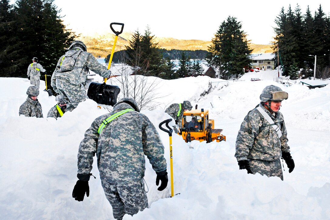 Alaska Army National Guardsmen clear the roof on a building in Cordova, Alaska, Jan. 9, 2012. The Guardsmen moved people into the area to clear roads, roofs and boats after a series of winter storms dropped nearly 18 feet of snow in the region.
