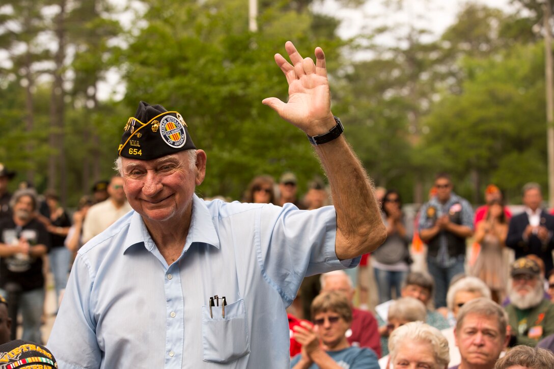 Larry Fitzpatrick, a former Onslow County Commissioner and retired Marine, stands and waves during the Vietnam Veterans Memorial rededication ceremony, at Lejeune Memorial Gardens in Jacksonville, May 31. Fitzpatrick was one of three who initiated the creation of the memorial. The ceremony honored the memory of those who perished during the war and celebrated the accomplishments and perseverance of Vietnam-era veterans.(U.S. Marine Corps photo by Cpl. Jackeline M. Perez Rivera/Released)