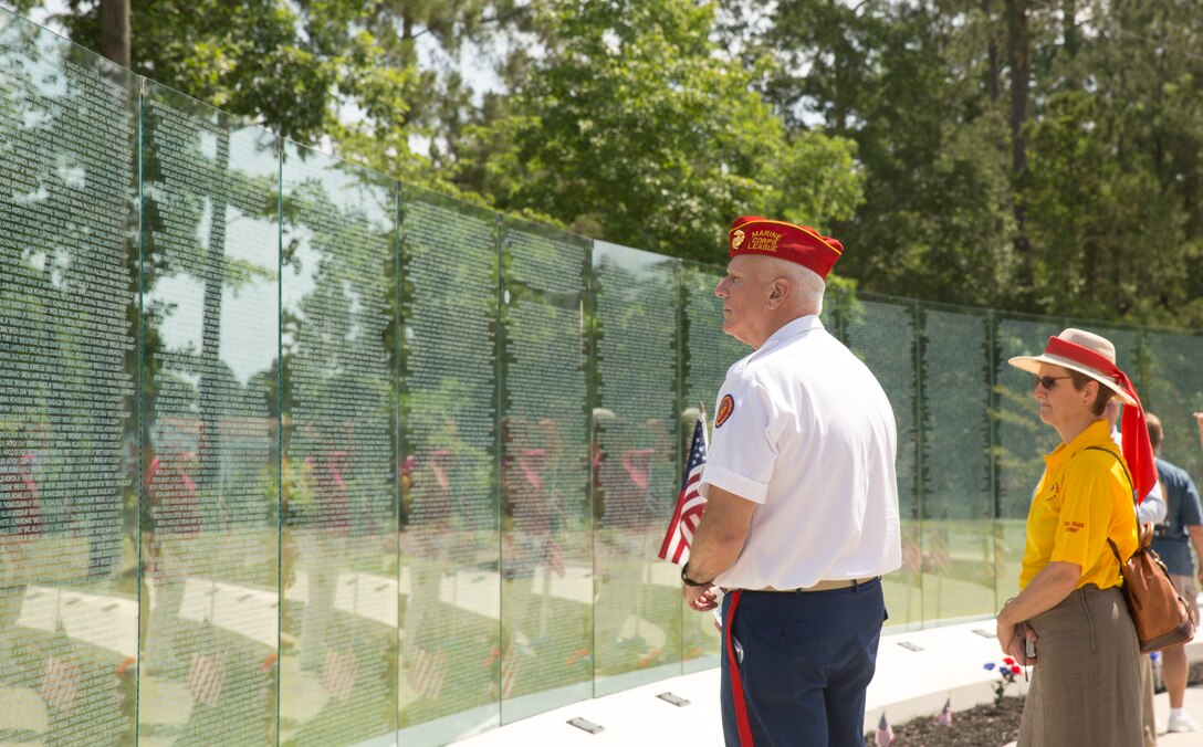 Michael North, a Vietnam-era Marine veteran, reads the names on the glass walls of the Vietnam Veterans Memorial after a rededications ceremony held for the memorial, at Lejeune Memorial Gardens in Jacksonville, N.C., May 31. North attended the event to reflect on his experiences and to represent his two brothers, who also served but were unable to attend. “We have always followed the flag,” said North, of his family. “We all feel very deeply about this.” The ceremony honored the memory of those who perished during the war and celebrated the accomplishments and perseverance of Vietnam-era veterans.(U.S. Marine Corps photo by Cpl. Jackeline M. Perez Rivera/Released)