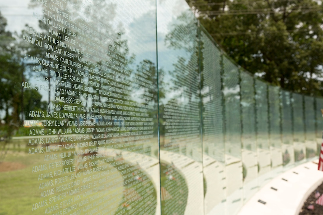 The glass walls at the Vietnam Veterans Memorial at Lejeune Memorial Gardens in Jacksonville, N.C., lists the names of the 58,229 men and women who lost their lives during the Vietnam War. A rededication ceremony was held to commemorate the addition of a gazebo to the memorial, May 31. The ceremony honored the memory of those who perished during the war and celebrated the accomplishments and perseverance of Vietnam-era veterans.(U.S. Marine Corps photo by Cpl. Jackeline M. Perez Rivera/Released)