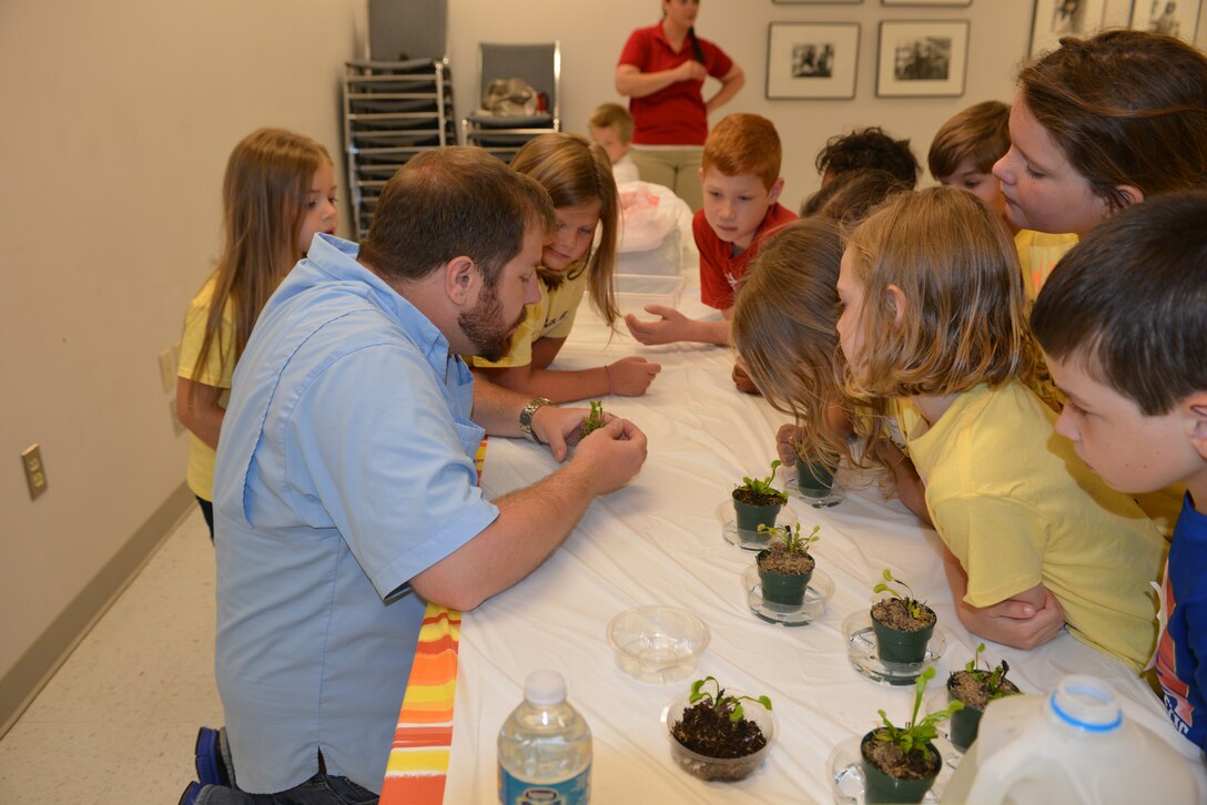 Casey Ehorn, a wetland biologist with the U.S. Army Corps of Engineers Nashville District Regulatory  Branch, shows kids how the Venus flytrap plant works at the Williamson County Junior Gardener Camp at the Agricultural Exposition Park June 3, 2014. 