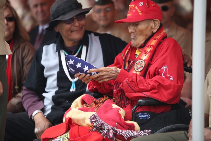 Chester Nez, the last surviving Navajo code talker from Platoon 382, holds an American flag that was handed to him by Pfc. Tiffany Boyd, data network specialist, at Code Talkers Hall on April 4, 2014. Nez passed away June 4, 2014.