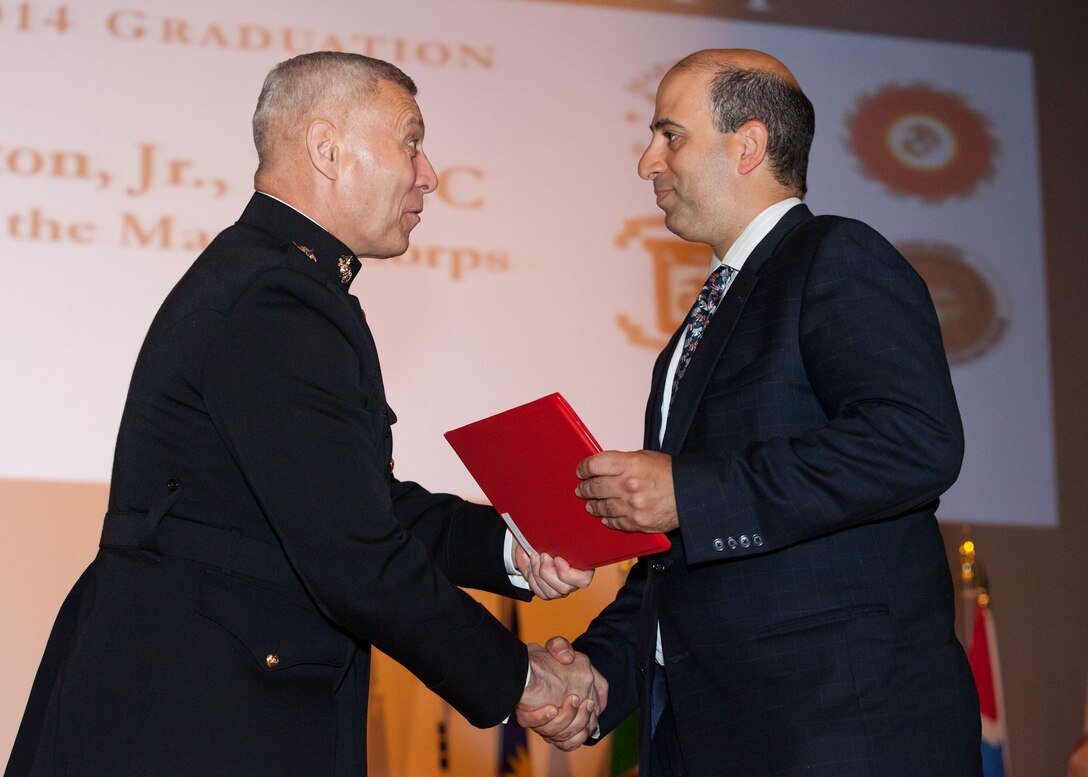 The Assistant Commandant of the Marine Corps, Gen. John M. Paxton, Jr., left, hands a diploma to a student who graduated from the Marine Corps University for the academic year of 2013-2014 at U.S. Marine Corps Base Quantico, Va., June 4, 2014. (U.S. Marine Corps by Cpl. Tia Dufour/Released)