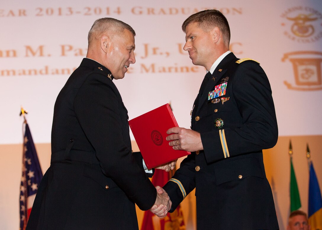 The Assistant Commandant of the Marine Corps, Gen. John M. Paxton, Jr., left, hands a diploma to a student who graduated from the Marine Corps University for the academic year of 2013-2014 at U.S. Marine Corps Base Quantico, Va., June 4, 2014. (U.S. Marine Corps by Cpl. Tia Dufour/Released)