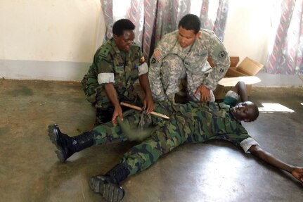 Ugandan People's Defense Forces medical provider Lt. Biira Kabonesa (left) and U.S. Army Cpt. Alexander Alba, a physician's assistant with Task Force Raptor, 3rd Squadron, 124th Cavalry Regiment, Texas Army National Guard, demonstrate applying an improvised tourniquet May 15, 2012. Alba and U.S. Navy Lt. Cmdr. Guillermo Navarro, an emergency physician with Expeditionary Medical Facility, Camp Lemonnier, Djibouti, attended an Advanced Combat Seminar here, May 14-18. U.S. service members are conducting various military-to-military exchanges in support of Combined Joint Task Force - Horn of Africa, whose mission is to build partnerships with nations in East Africa.