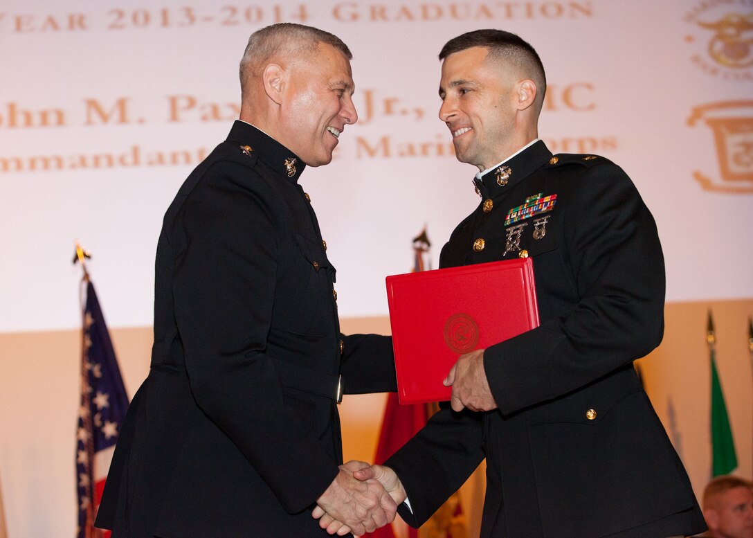 The Assistant Commandant of the Marine Corps, Gen. John M. Paxton, Jr., left, hands a diploma to a student who graduated from the Marine Corps University for the academic year of 2013-2014 at U.S. Marine Corps Base Quantico, Va., June 4, 2014. (U.S. Marine Corps by Cpl. Tia Dufour/Released)
