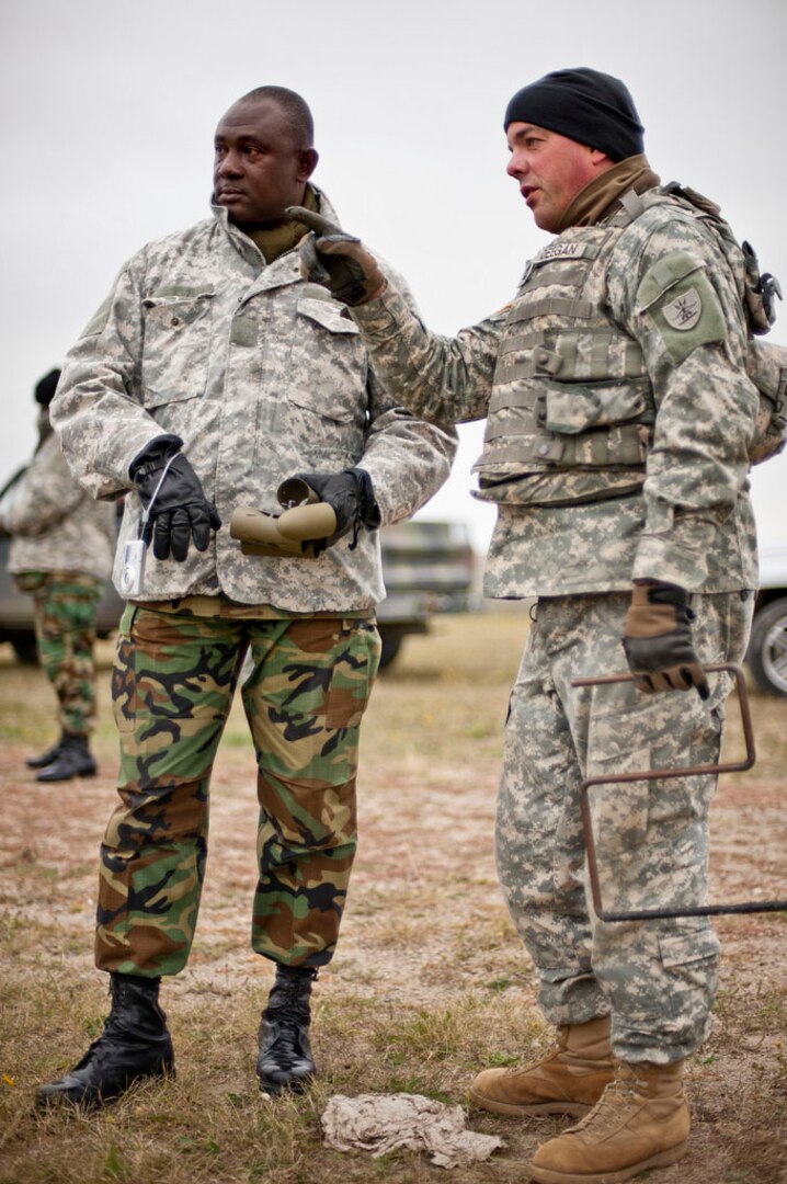 Sgt. 1st Class Paul Deegan, right, visits with Warrant Officer Class 1 Benjamin Afful, of the Ghanaian Armed Forces, prior to setting up explosives for a demolition range Sept. 17, 2011, at Camp Grafton South, near Devils Lake, North Dakota. Deegan traveled to Ghana in February 2011 as part of an engineer instructor exchange. Afful then traveled to North Dakota in September for the latter half of the exchange. The events were part of the Department of Defense-sponsored State Partnership Program, which has paired North Dakota with Ghana since 2004. 