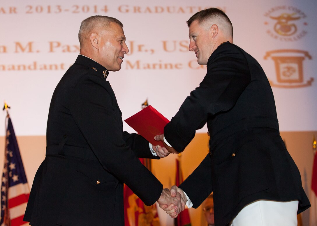 The Assistant Commandant of the Marine Corps, Gen. John M. Paxton, Jr., left, hands a diploma to a student who graduated from the Marine Corps University for the academic year of 2013-2014 at U.S. Marine Corps Base Quantico, Va., June 4, 2014. (U.S. Marine Corps by Cpl. Tia Dufour/Released)