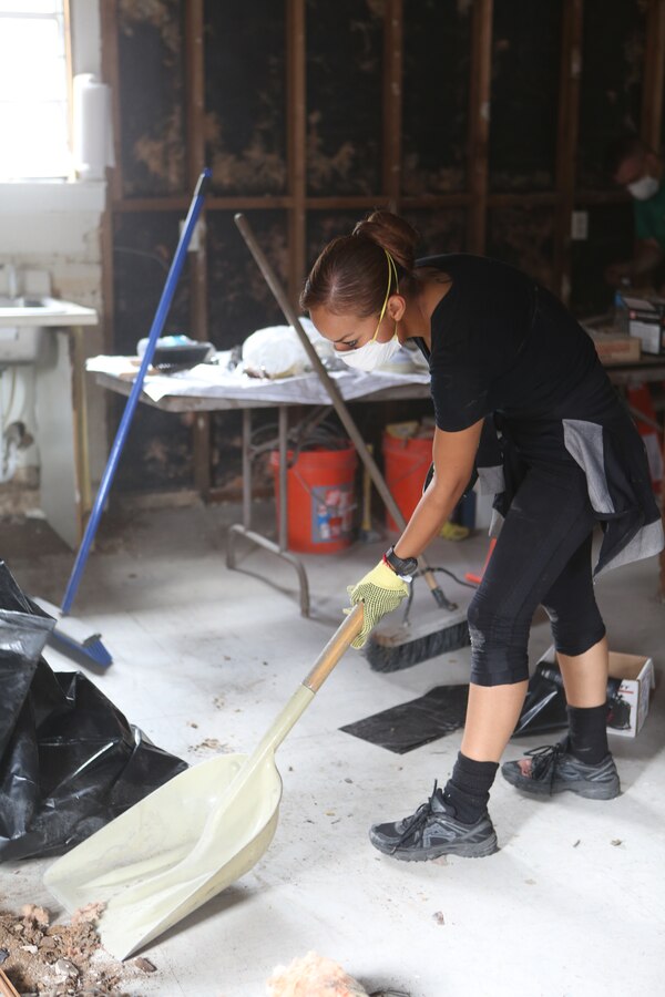 Cpl. Estephania de Leon, an Administrative Specialist with the Marine Corps Individual Reserve Support Activity, Force Headquarters Group, scoops up insulation from the floor of the Veterans of Foreign Wars Post 8973, June 4, 2014. Volunteers from Marine Forces Reserve, Naval Air Station-Joint Reserve Base Belle Chasse and the community lent a helping hand to rebuild the post. (U.S. Marine Corps photo by Lance Cpl. Sara Graham)