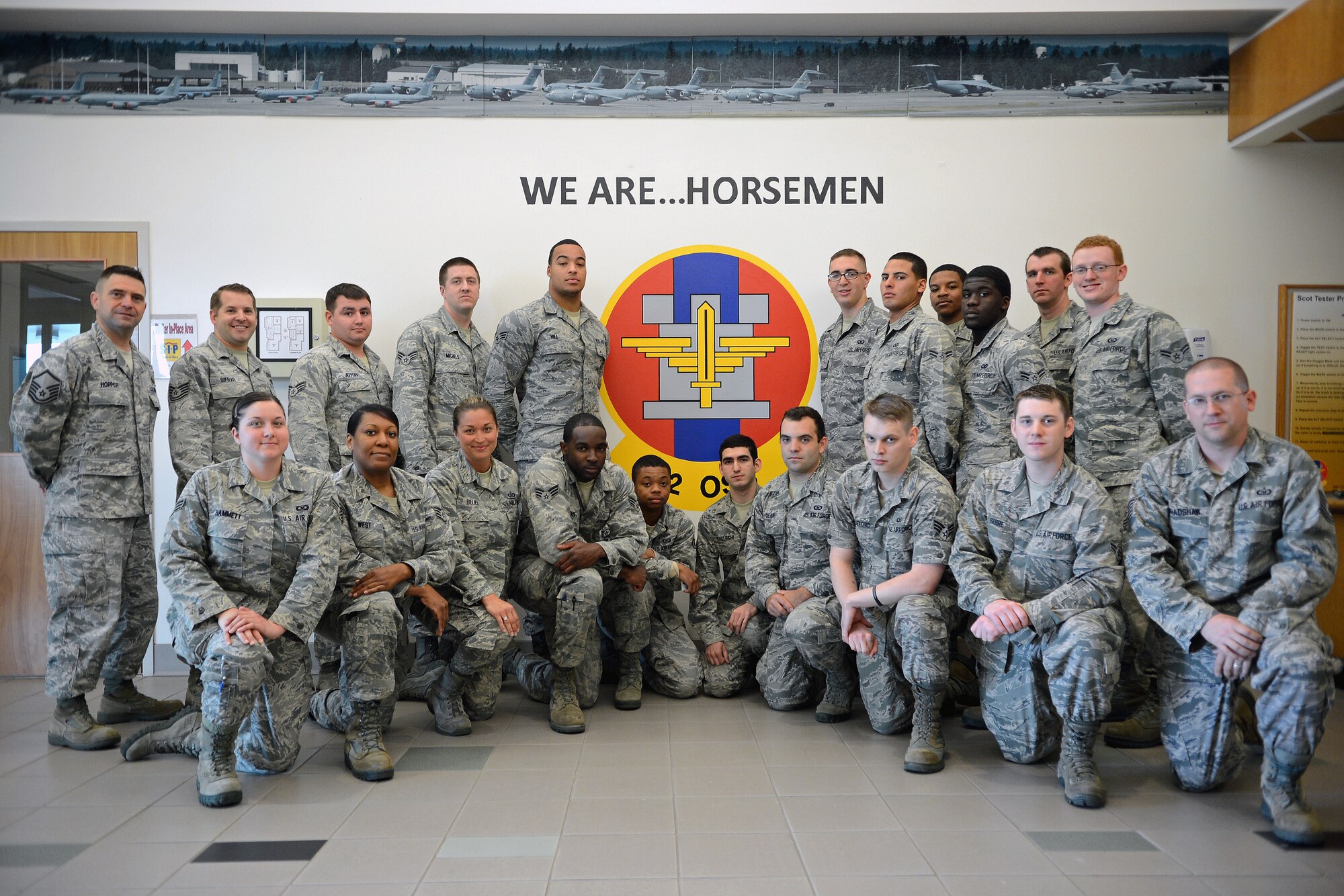 Airmen from the 62nd Operations Support Squadron aircrew flight equipment shop pose for a photo in front of a mural painted by their fellow teammate Senior Airman Danielle Snyder, 62nd Operations Support Squadron aircrew flight equipment journeyman, June 5, 2014 at Joint Base Lewis-McChord, Wash. Snyder is currently deployed and completed the mural before departing. (U.S. Air Force photo/Airman 1st Class Jacob Jimenez)   