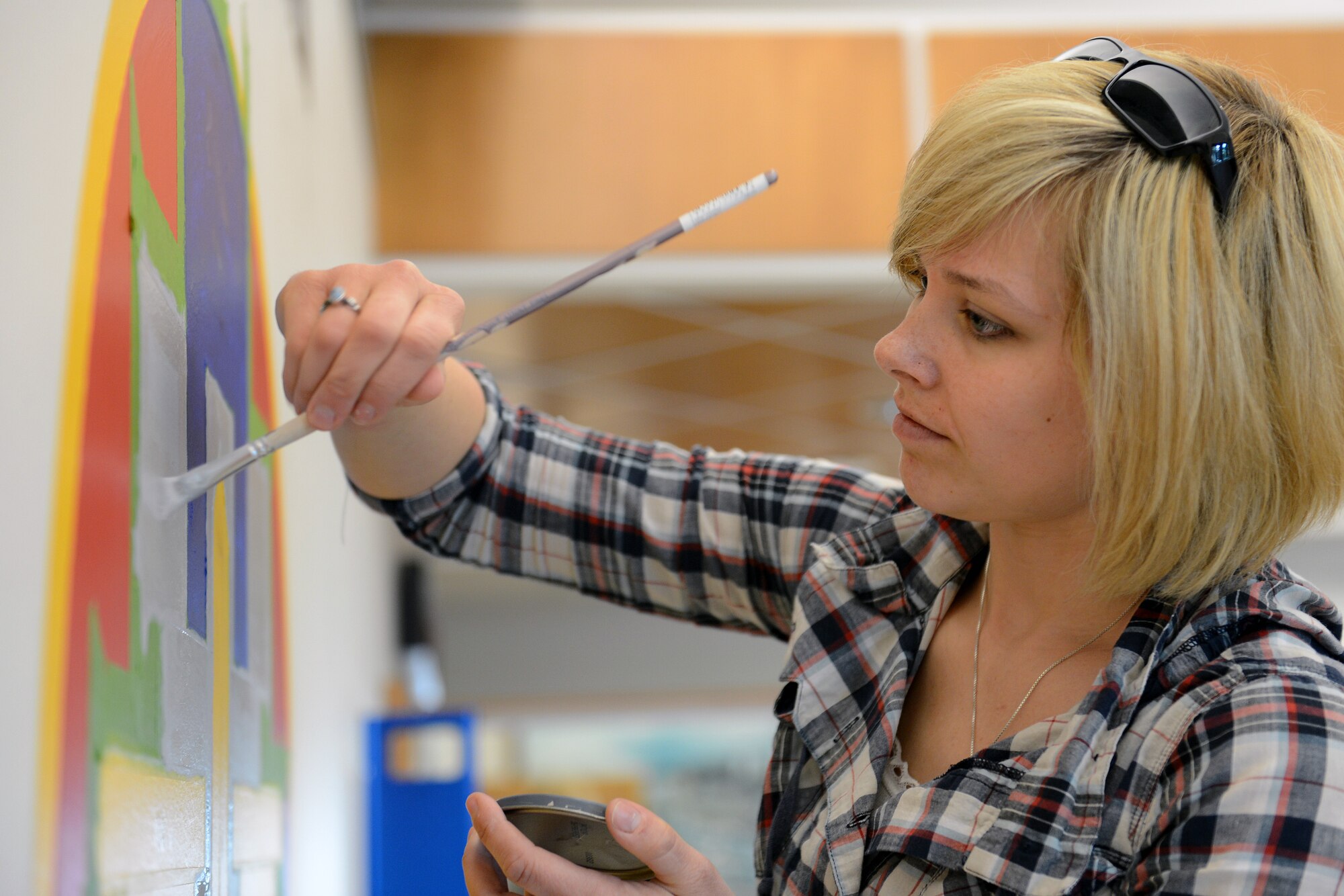 Senior Airman Danielle Snyder, 62nd Operations Support Squadron aircrew flight equipment journeyman, adds a second coat of paint to a mural of her squadrons patch May 5, 2014 at Joint Base Lewis-McChord, Wash. The mural’s segments took more than six coats of paint to complete. (U.S. Air Force photo/Airman 1st Class Jacob Jimenez)  