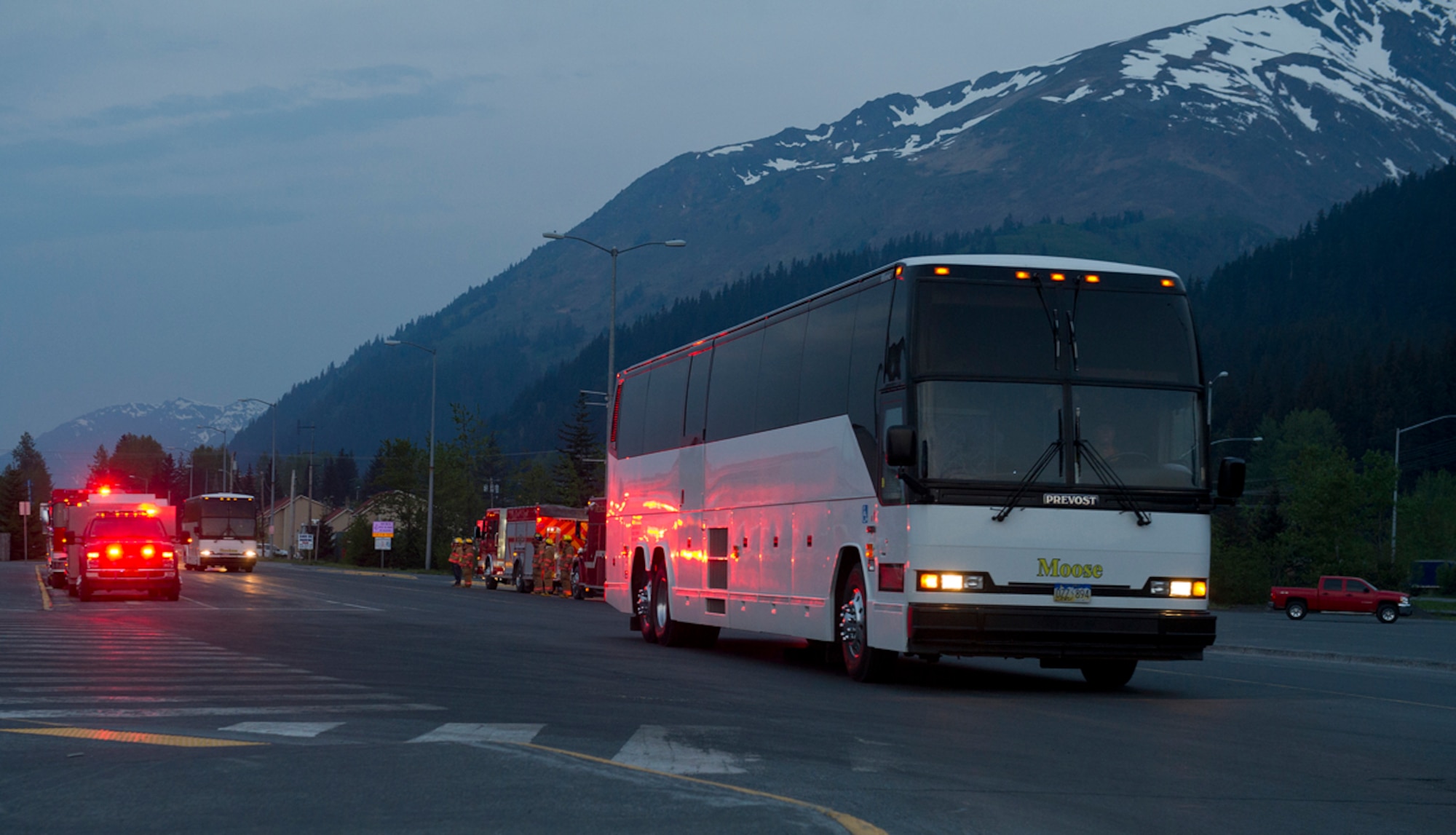 Buses carrying Joint Base Elmendorf-Richardson service members pull up to the docks at the start of the 8th Annual Armed Services Combat Fishing Tournament in Seward, Alaska, May 22, 2014. The local fire department flashed their lights as they waved to welcome these service members to Seward. (U.S. Air Force photo/Staff Sgt. Zachary Wolf)
