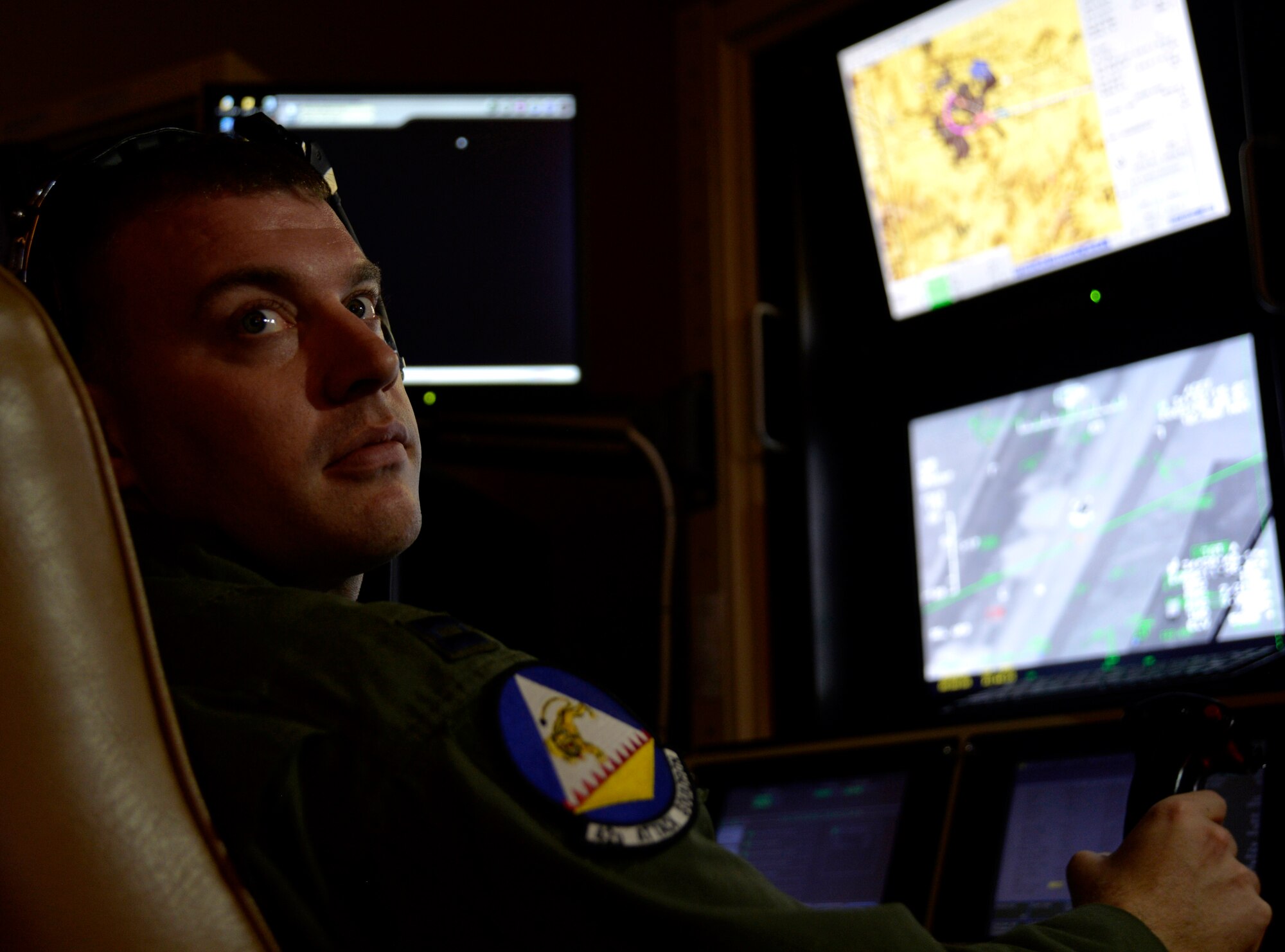 Capt. Andrew, 18th Reconnaissance Squadron pilot, flies a remotely piloted aircraft using a flight training simulator May 28, 2014, after flying the 65th combat air patrol, which launched earlier that morning. Andrew was selected to fly the 65th CAP, an initiative set by then Secretary of Defense Robert Gates Dec. 23, 2009 (Last names have been withheld for security purposes). (U.S. Air Force photo by Staff Sgt. Adawn Kelsey/Released)