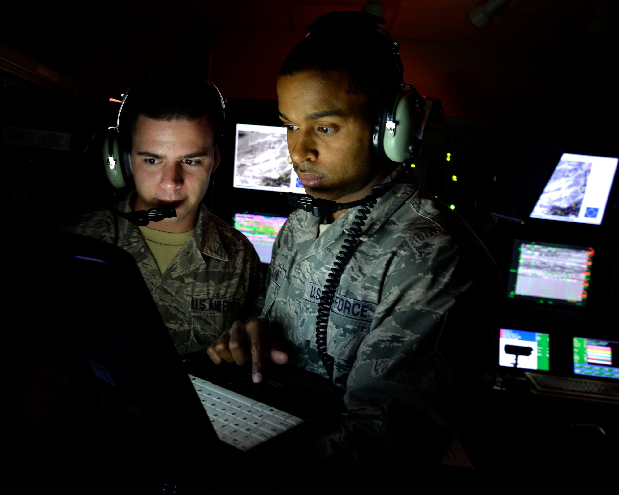 Airman First Class Ryder Luzadder, 432nd Aircraft Communications Maintenance Squadron communications technician, left, and Staff Sgt. Jose Feliciano, 432nd ACMS communications technician, look over technical orders for a ground control station May 28, 2014. The 432nd ACMS is the only squadron of its kind in the Air Force and is responsible for providing 24/7, 365-day maintenance support to the communication infrastructure that supports the wing's global remotely piloted aircraft operations. (U.S. Air Force photo by Staff Sgt. Adawn Kelsey/Released)
