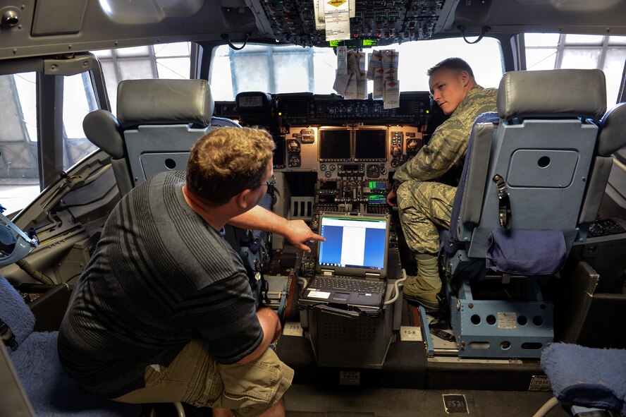 James Martin (left), 62nd Aircraft Maintenance Squadron integrated avionics technician, verifies with Tech. Sgt. Joshua Taylor (right), 62nd Maintenance Squadron engineering and logistics liaison, the upload for a navigation database for a C-17 Globemaster III June 4, 2014, at Joint Base Lewis-McChord, Wash. The industry of aviation is at an all-time high, and with hundreds of thousands of aircraft in the skies every single day, navigation systems must be on the cutting edge of technology. (U.S. Air Force photo/Staff Sgt. Russ Jackson)