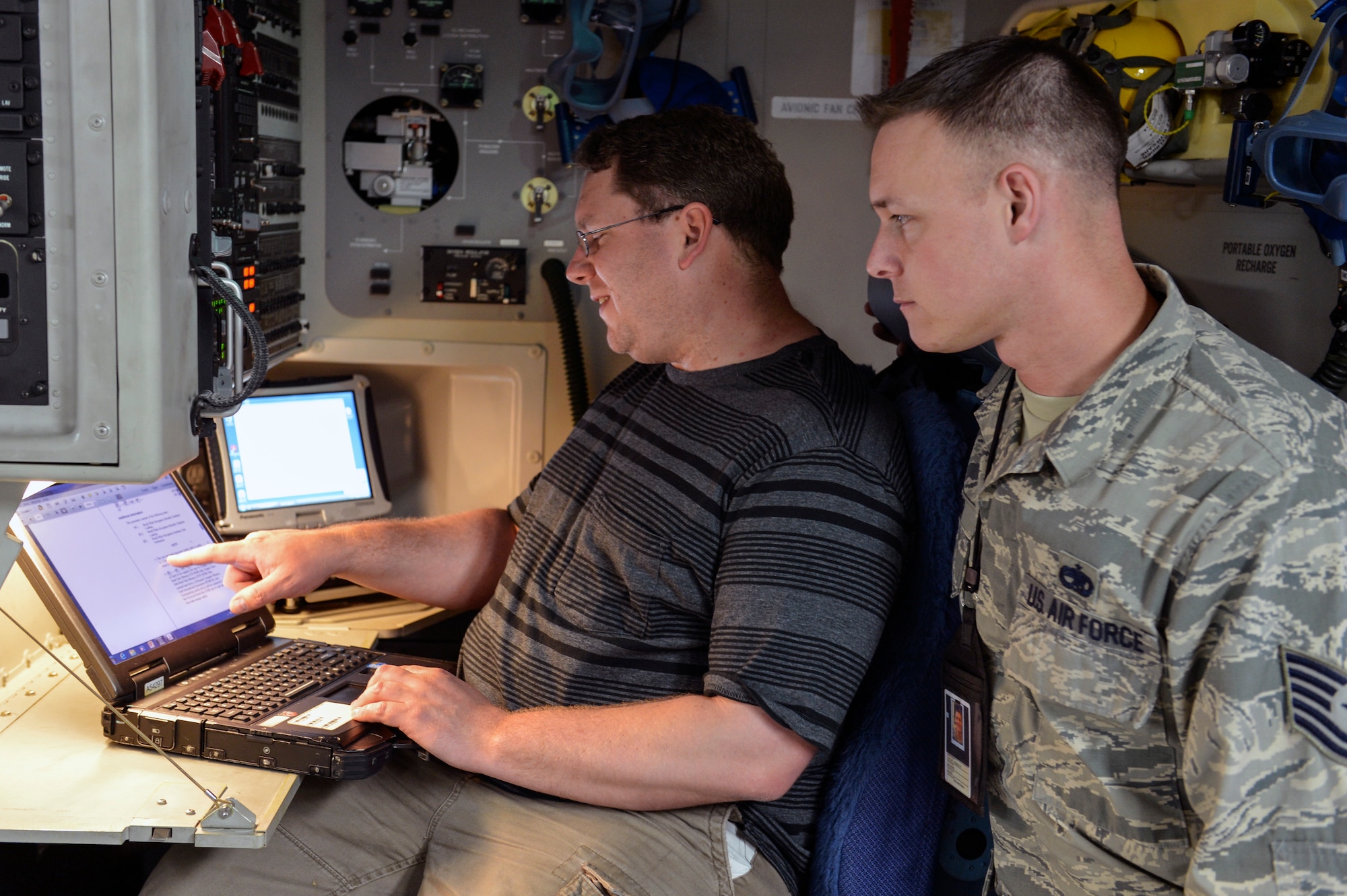 James Martin (left), 62nd Aircraft Maintenance Squadron integrated avionics technician, informs Tech. Sgt. Joshua Taylor (right), 62nd Maintenance Squadron engineering and logistics liaison, of current upload procedures for a navigation database for a C-17 Globemaster III June 4, 2014, at Joint Base Lewis-McChord, Wash. The databases provide C-17 aircrews with the data they need to navigate the increasingly complex global airspace system. (U.S. Air Force photo/Staff Sgt. Russ Jackson)
