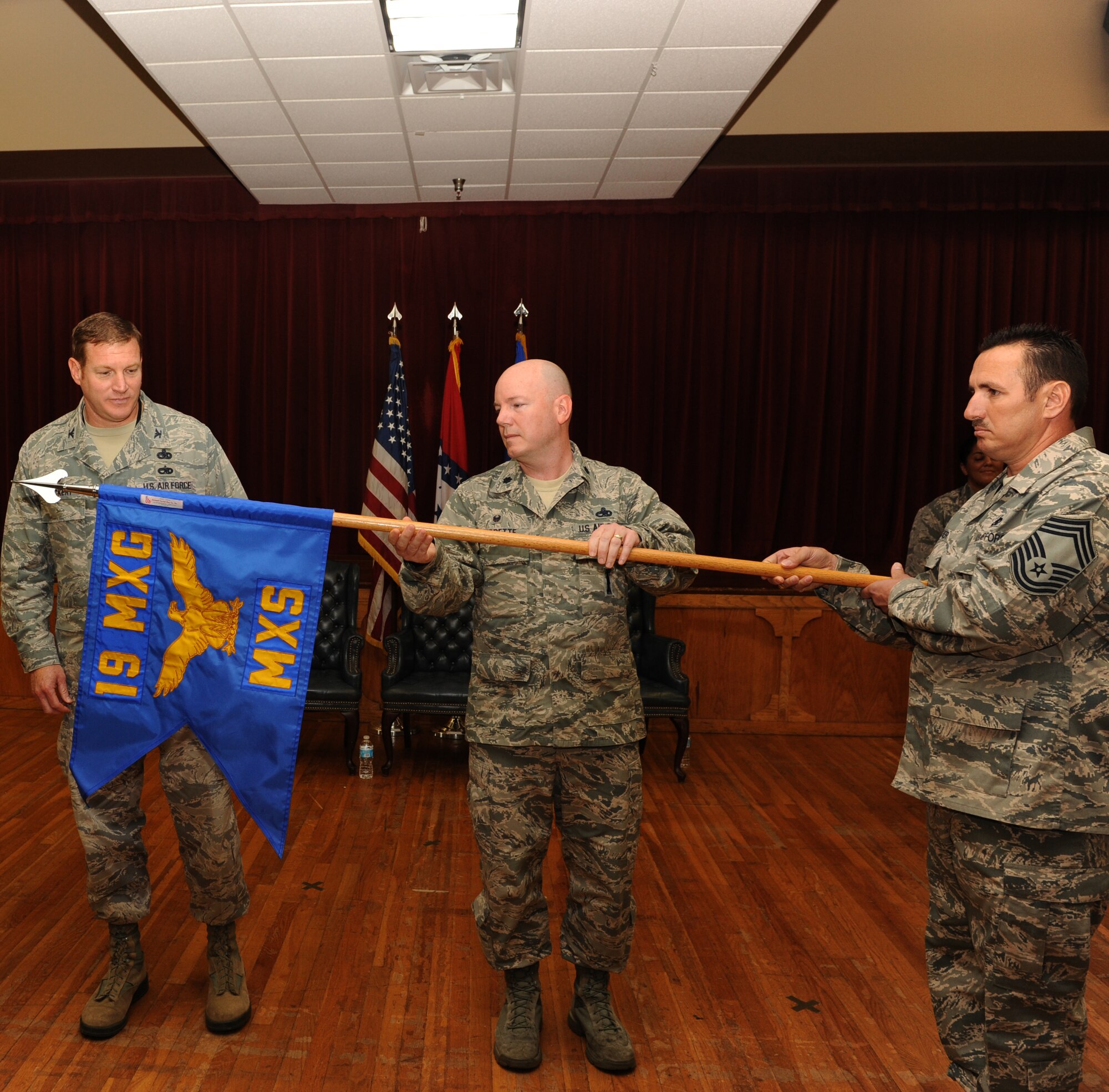 Lt. Col. Jeffrey Burdette, 19th Maintenance Squadron commander, unveils the new squadron guidon during a ceremony May 28, 2014, at Little Rock Air Force Base, Ark. The 19th Component Maintenance Squadron was inactivated, and its personnel merged with the 19th Equipment Maintenance Squadron; the 19th EMS was then redesignated as the 19th MXS. (U.S. Air Force photo by Airman 1st Class Scott Poe)