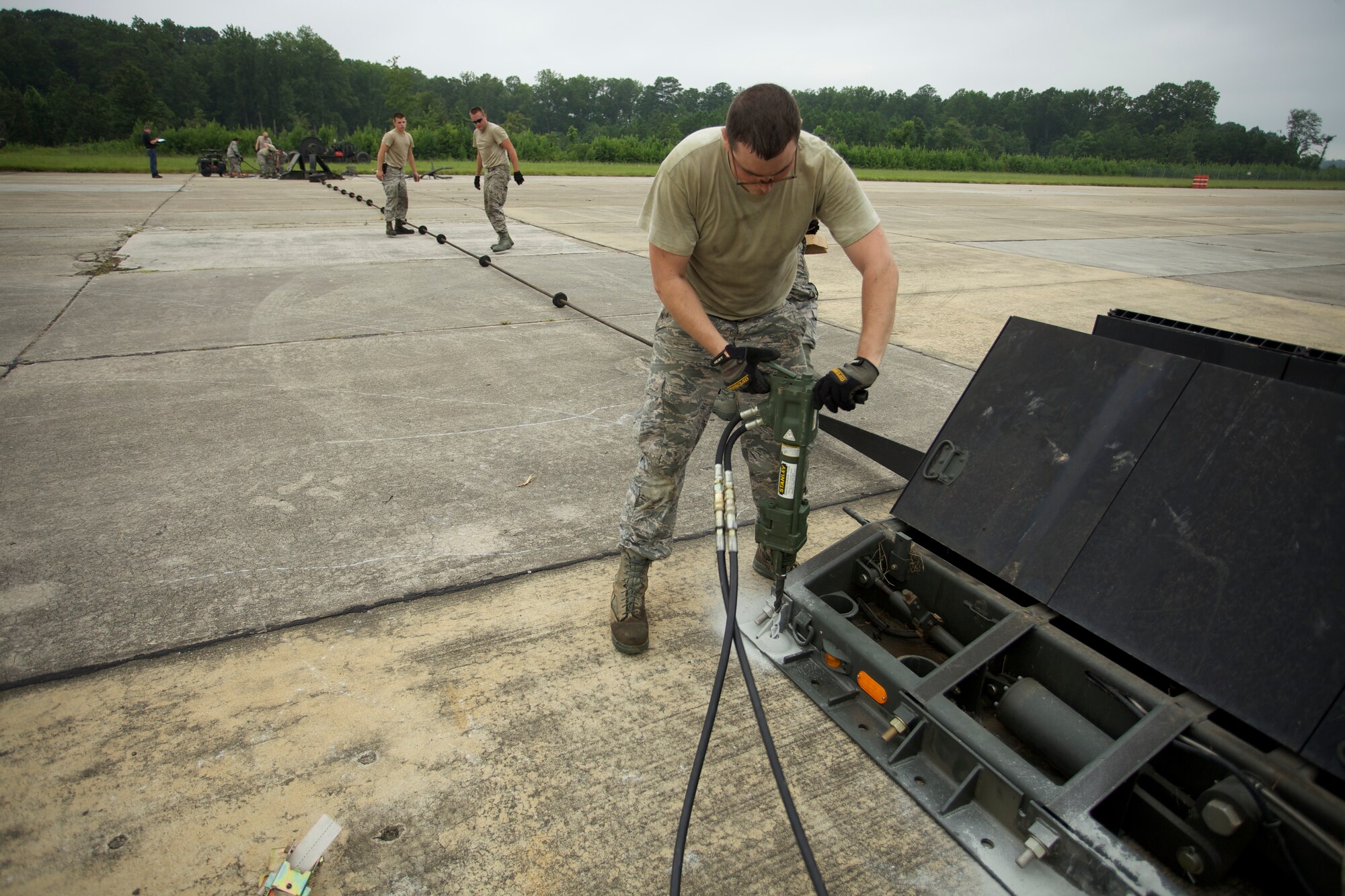 Power Production Technician Airman 1st Class Franklyn Houghton, 99th Civil Engineer Squadron, Nellis Air Force Base, Nev., anchors a mobile runway edge sheave at Dobbins Air Reserve Base, Ga., Aug. 8, 2013. Dobbins is one of four locations for mission essential equipment training, or MEET, which gives civil engineers experience working with specialized equipment used in contingency operations but not typically available at home station. MEET is part of the CE contingency training program managed by AFCEC’s Readiness Directorate. (U.S. Air Force photo/Eddie Green/Released)