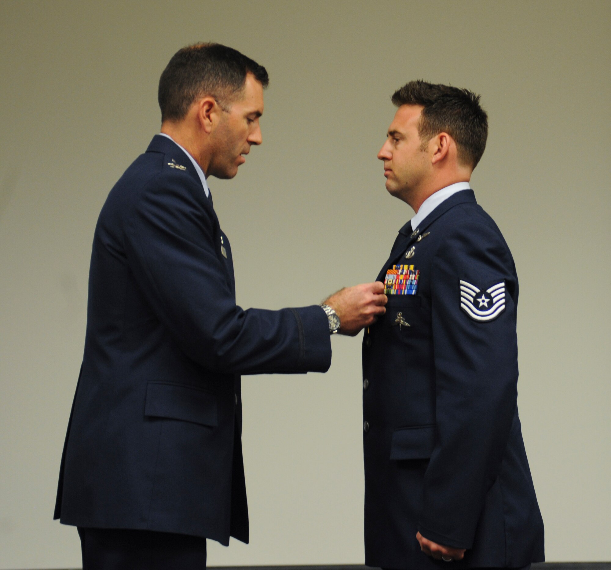 U.S. Air Force Tech. Sgt. Brandon Daugherty, 306th Rescue Squadron pararescueman, receives a Bronze Star Medal with valor from Col. Sean Choquette, 563rd Rescue Group commander, at Davis-Monthan Air Force Base, Ariz., June 2, 2014. Daugherty distinguished himself by heroism as pararescue team leader for the 46th Expeditionary Rescue Squadron, 651st Air Expeditionary Group, 451st Air Expeditionary Wing while engaged in action against an enemy forces in Afghanistan on  Feb. 21, 2012. (U.S. Air Force photo by Senior Airman Sivan Veazie/Released)