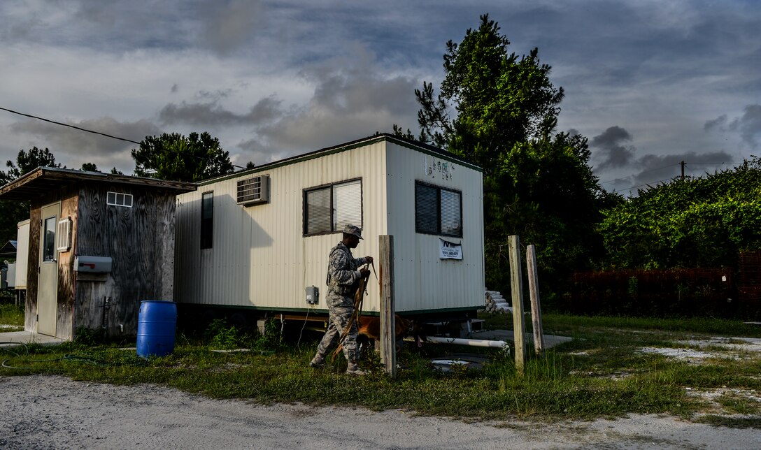 Staff Sgt. Corey Rainge, 1st Special Operations Security Forces Squadron military working dog handler and his dog Cora, search around a trailer for simulated explosives on Hurlburt Field, Fla., May 26, 2014. The teams primary mission on base is to support the flightline, help secure the base and protect the people who come in and out of the gates. (U.S. Air Force photo/Senior Airman Christopher Callaway) 