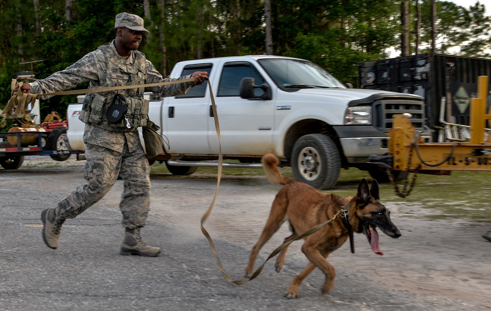 Staff Sgt. Corey Rainge, 1st Special Operations Security Forces Squadron military working dog handler, is led by his companion on Hurlburt Field, Fla., May 26, 2014. The team has recently completed certification before the 1st SOSFS commander. (U.S. Air Force photo/Senior Airman Christopher Callaway) 