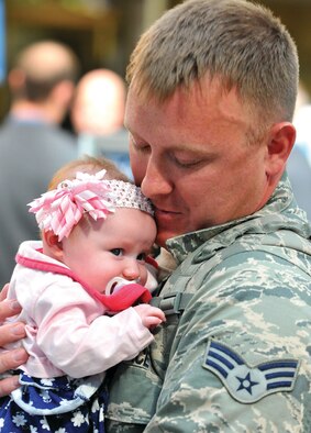 WRIGHT-PATTERSON AIR FORCE BASE, Oho - Family and friends greet Senior Airman Christopher Peterson, 87th Aerial Port Squadron, as he meets his 3-month-old daughter, Olivia, for the first time at the Dayton International Airport May 3 upon his return home from his deployment. Olivia was born while Peterson was deployed to the Transit Center, Manas, Kyrgyzstan.  (U.S. Air Force photo/Tech. Sgt. Frank Oliver)