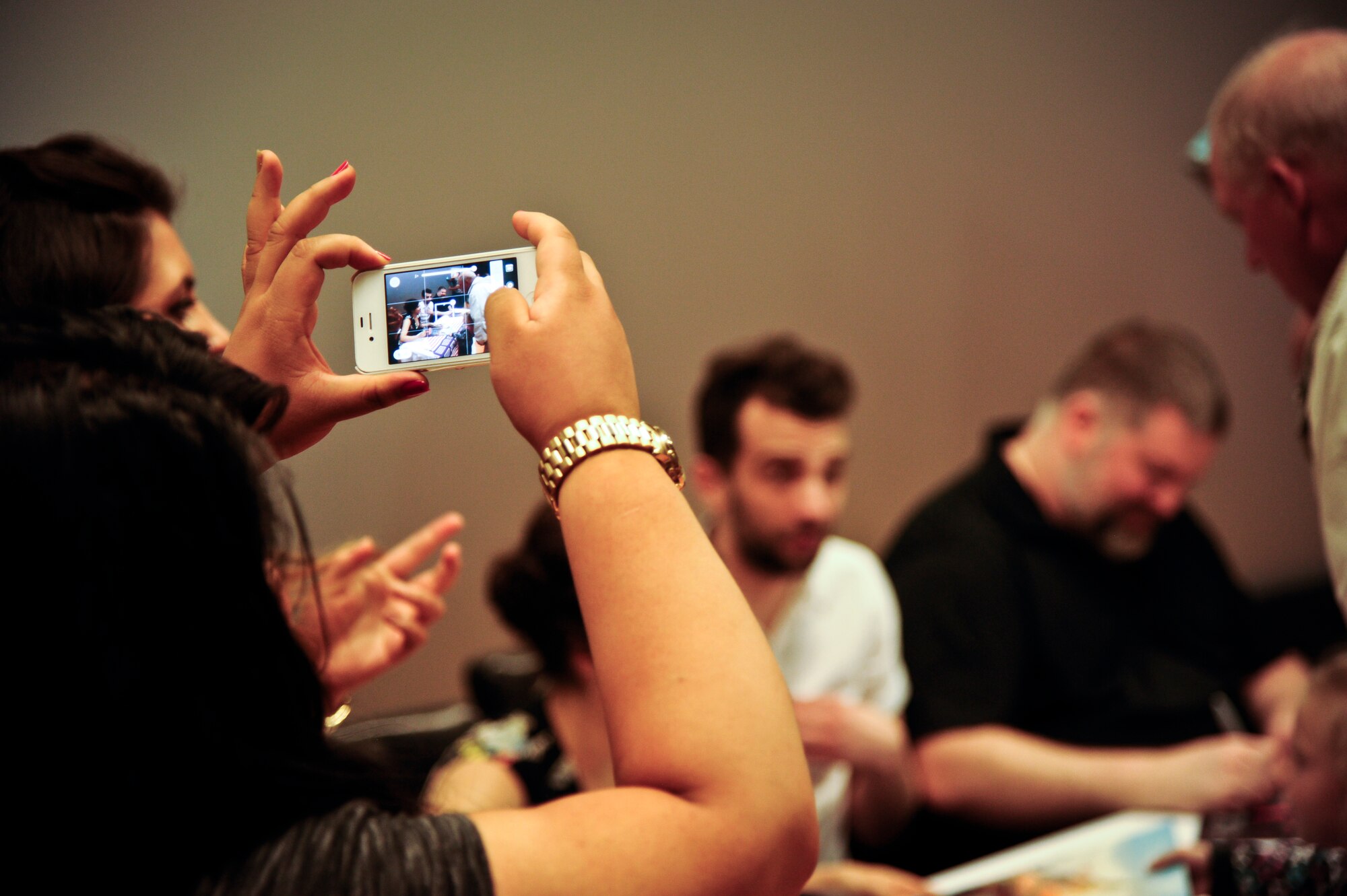 An audience member attending an advanced screening of “How to Train Your Dragon 2” takes photos of cast members Dean DeBlois, writer and director, Jay Baruchel, voice of Hiccup, and America Ferrara, voice of Astrid, June 4, 2014, at Joint Base McGuire-Dix-Lakehurst, N.J. The visit to JB MDL was part of a USO tour allowing military families the ability to view the movie a week early, ask cast members questions and get autographs. (U.S. Air Force photo by Staff Sgt. Scott Saldukas/ Released)  