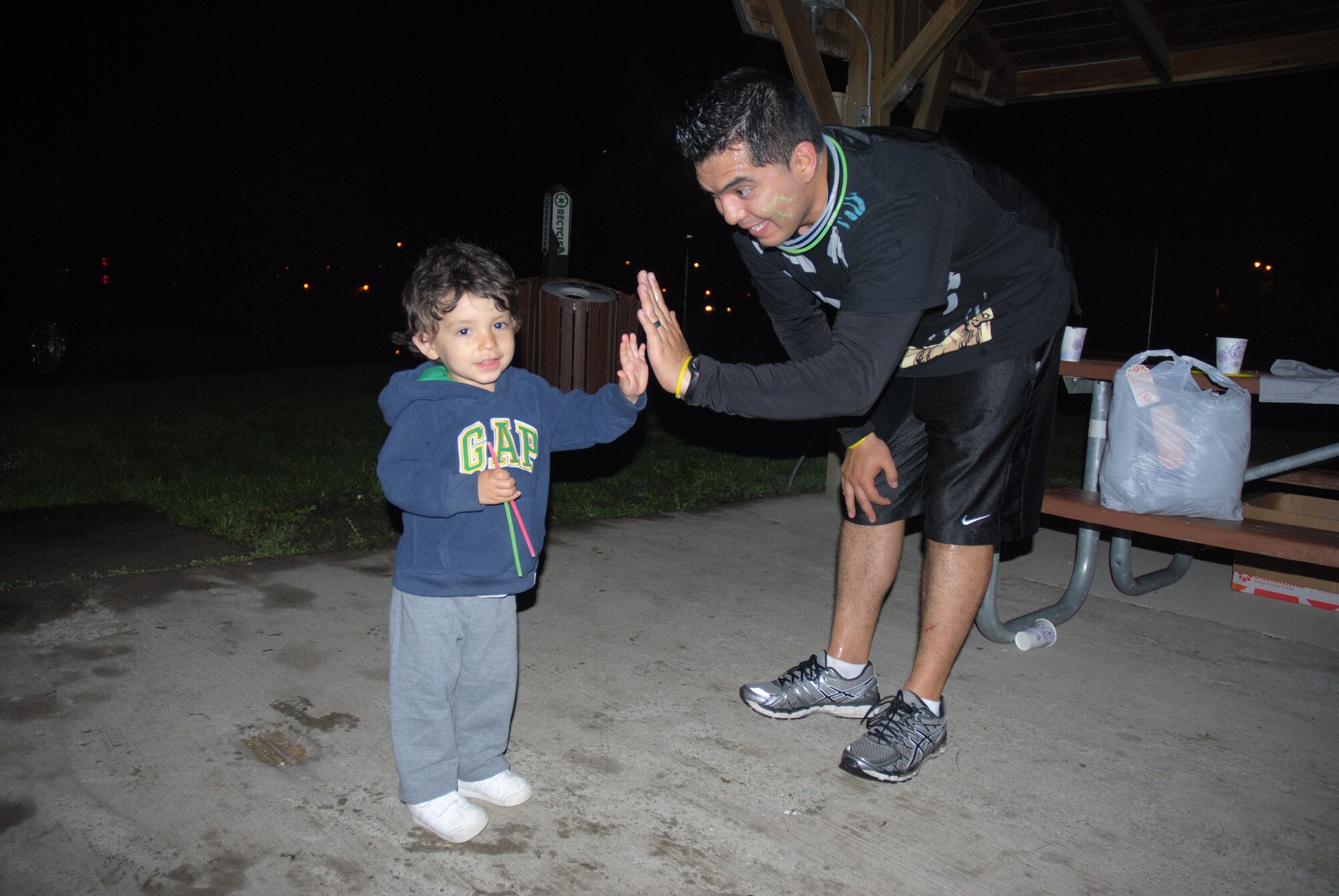 Julius Cervantes, age 2, gives his daddy, Senior Airman Marco Cervantes, a high-five after completing the 5K Glow Run sponsored by the Air Force Sergeants Association, Chapter 964 on May 30, 2014, on Grand Forks Air Force Base, N.D. In addition to raising money for the American Cancer Society’s Relay for Life, the run was designed to provide a fun and unique experience for military members and their families. (U.S. Air Force photo/Staff Sgt. Luis Loza Gutierrez)
