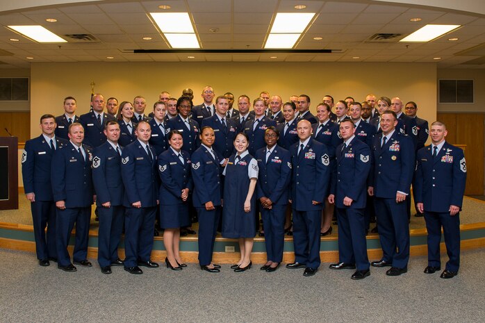 Col. Jeffrey DeVore, Joint Base Charleston commander (second from left), Col. John Lamontagne, 437th Airlift Wing commander (second from right), Chief Master Sgt. Mark Bronson, 628th Air Base Wing command chief (left), and Chief Master Sgt. Shawn Hughes, 437th Airlift Wing command chief (right), pose for a group photo with Airmen who have reached career milestones by earning their Community College of the Air Force degrees June 4, 2014, at Joint Base Charleston, S.C. More than 80 Airmen were recognized during the ceremony.  (U.S. Air Force photo / Senior Airman George Goslin) 