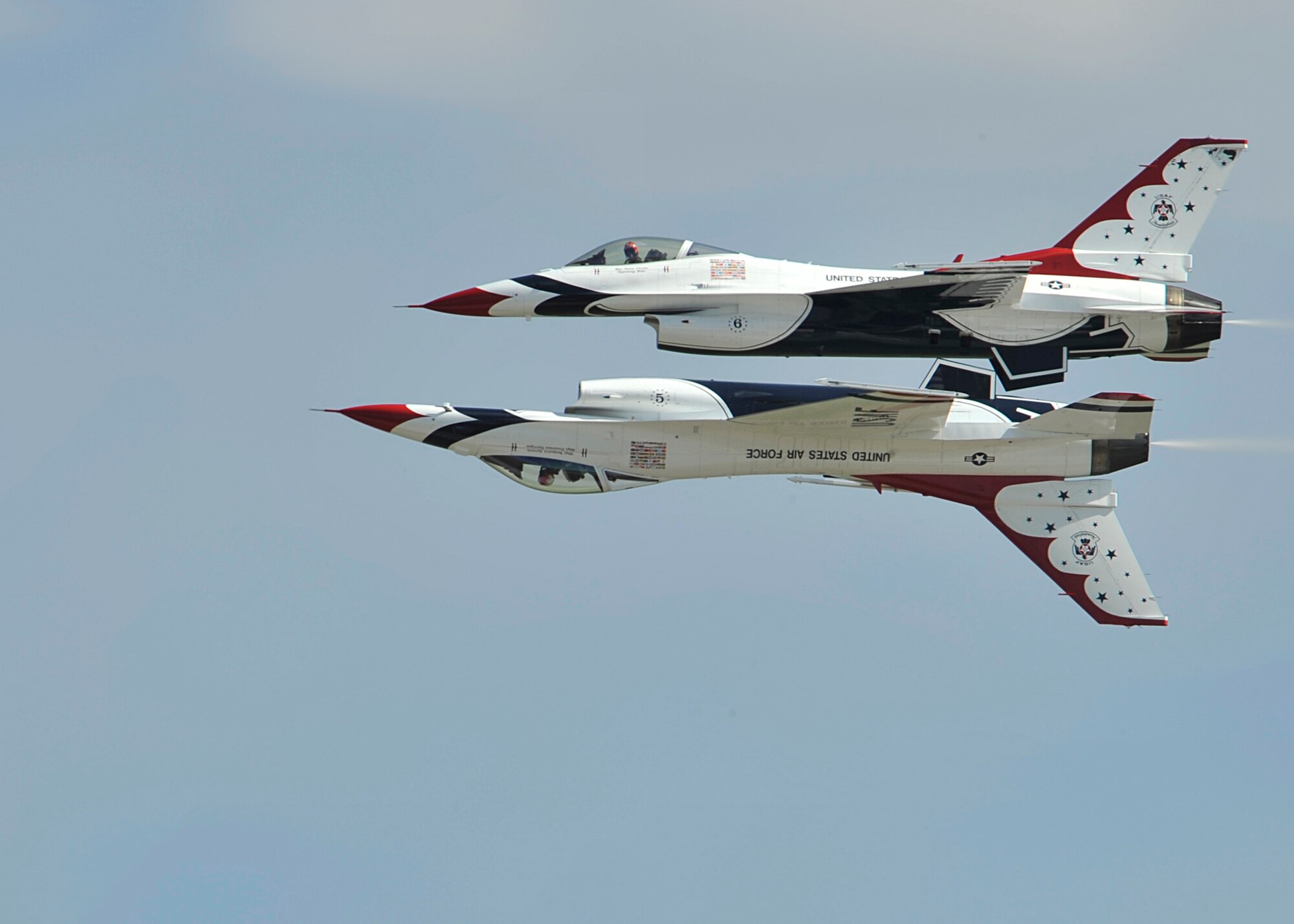 Thunderbirds five and six perform a reflection pass during SkyFest 2014 at Fairchild Air Force Base, Wash., May 31, 2014. The pilots perform approximately 30 maneuvers in a demonstration. The entire show, including ground and air, runs about an hour and fifteen minutes. The season lasts from March to November, with the winter months used to train new members. (U.S. Air Force photo by Senior Airman Mary O'Dell/Released)
