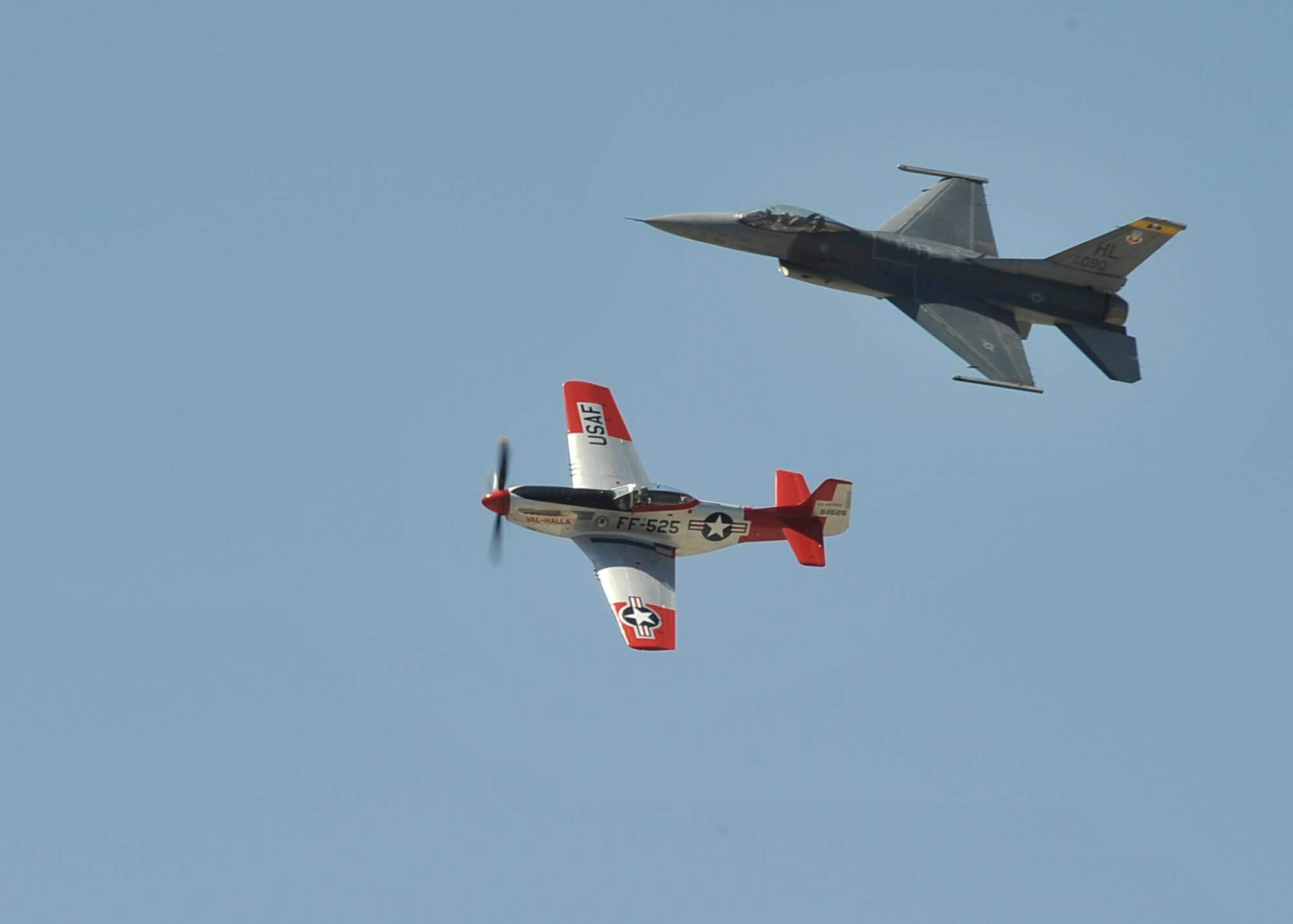 A P-51 Mustang flies in formation with an F-16 Fighting Falcon as part of a heritage flight demonstration during SkyFest 2014 at Fairchild Air Force Base, Wash., June 1, 2014. The U.S. Air Force Heritage Flight program presents the evolution of USAF air power by flying today's state-of-the-art fighter aircraft in close formation with vintage fighter aircraft. (U.S. Air Force photo by Senior Airman Mary O'Dell/Released)