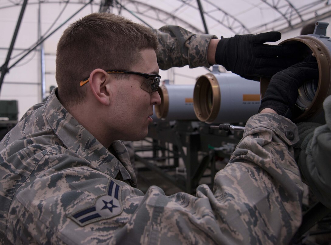 U.S. Air National Guard Airman 1st Class Nate Limoge of the 158th Fighter Wing Vermont Air National Guard, installs the guidance section to a laser-guided munition, South Burlington, Vt., April 5, 2014. As part of the training airmen work as a team to install both the tail assembly and the guidance section on a laser-guided munition. (U.S. Air National Guard photo by Airman 1st Class Jeffrey Tatro)
