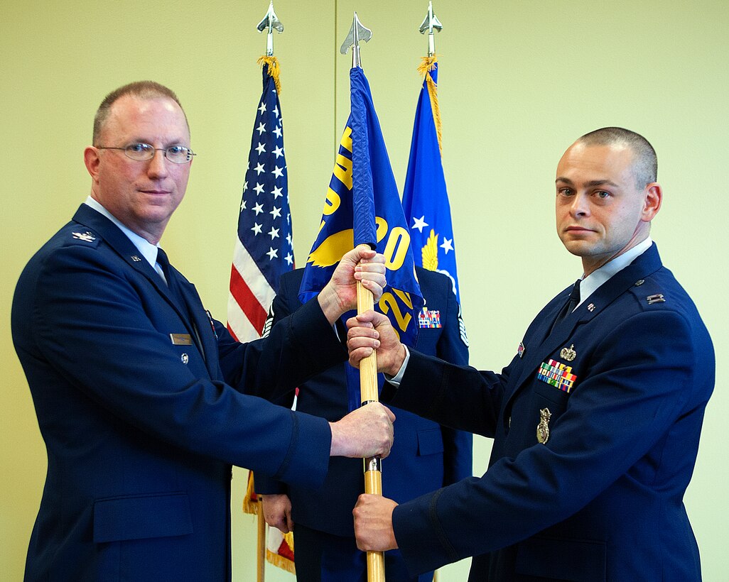 Col. Scott Fox, 20th Air Force vice commander, passes the 620th Ground Combat Training Squadron guidon to Capt. Clifford Piernick as he assumes command of the squadron during a change of command ceremony in Guernsey, Wyo., May 20, 2014. The 620th GCTS, part of the 20th Air Force, trains missile wing security forces in the protection and safe keeping of the nation’s ICBM resources. (U.S. Air Force photo by R.J. Oriez)