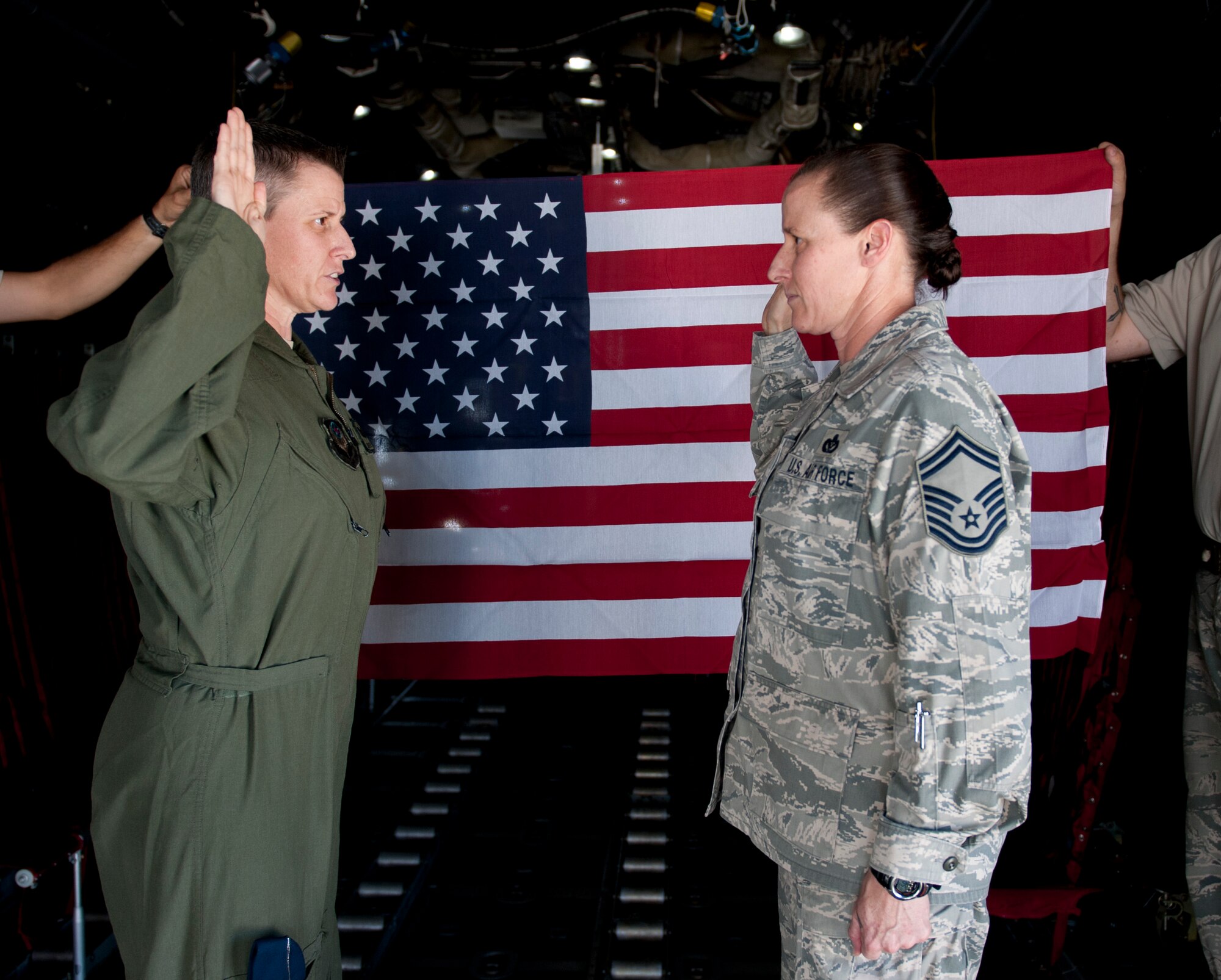 Senior Master Sgt. Cathrine Beck, HQ Air Force Special Operations Command/A7 program manager, repeats the enlistment oath during her re-enlistment ceremony in the back of a MC-130P Combat Shadow on the flightline on Hurlburt Field, Fla., May 21, 2014. Beck’s fraternal twin sister, Maj. Caroline Beck performed her re-enlistment. (U.S. Air Force photo/Senior Airman Krystal M. Garrett) 