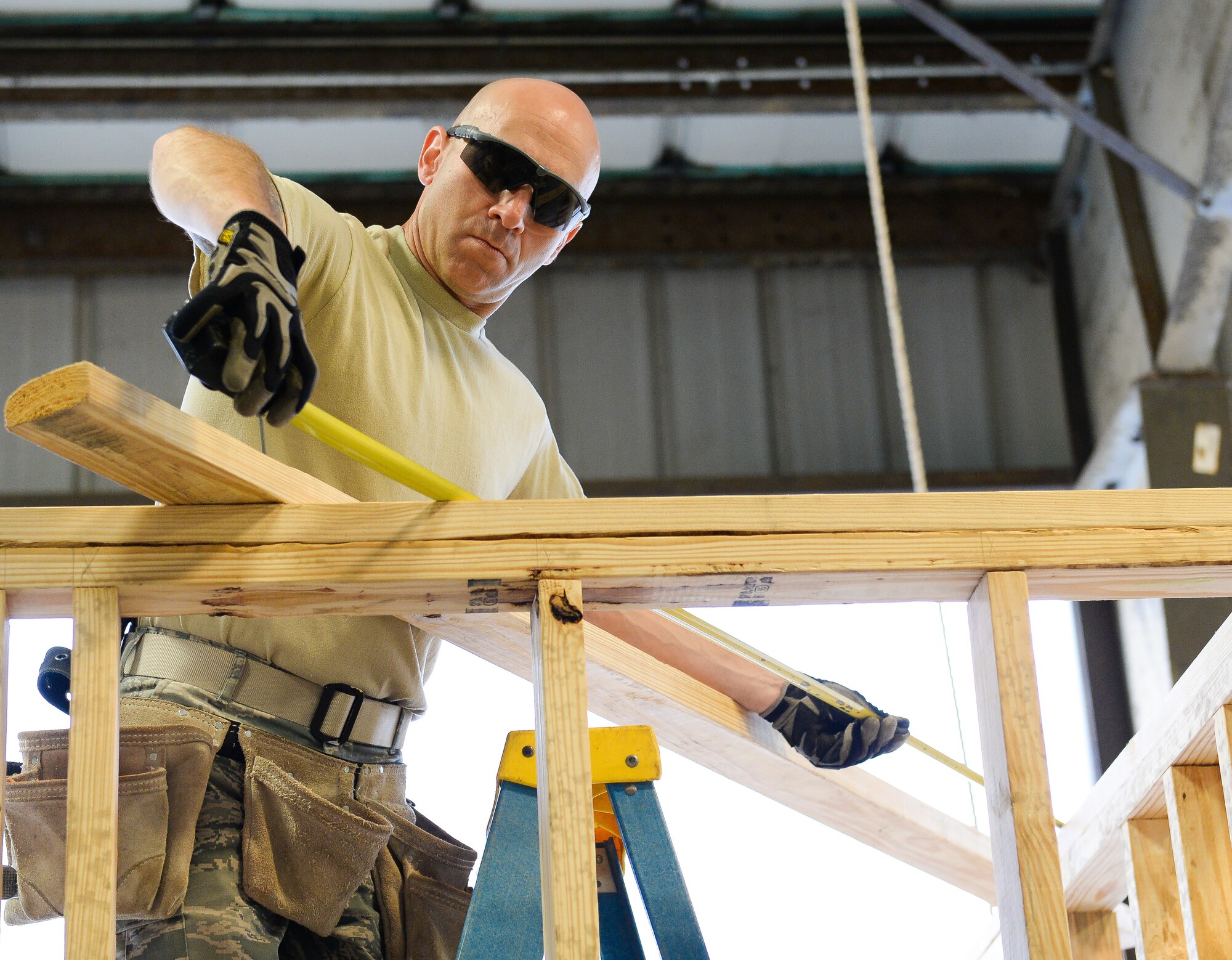 U.S. Air Force Senior Airman Axel Fiksman, from the 116th Civil Engineering Squadron (CES) based out of Robins Air Force Base, Ga., Georgia Air National Guard, takes a measurement during the construction of a wall during Silver Flag training at Tyndall Air Force Base, Fla., April 15, 2014. During the weeklong course, Guardsmen from the 116th CES and more than 30 other U.S. Air Force and Air National Guard units trained on building and maintaining bare-base operations at a forward-deployed location. In addition, they honed their combat and survival skills and repaired simulated bomb-damaged runways, set up base facilities and established various critical base operating support capabilities. More than 30 Airmen from the 116th CES attended the exercise that consisted of extensive classroom and hands-on training culminating in an evaluation of learned skills on the last day of class. (U.S. Air National Guard photo by Master Sgt. Roger Parsons/Released)

