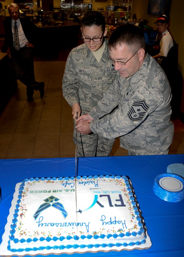Chief Master Sgt. Kevin Peterson, 28th Bomb Wing command chief, and Airman 1st Class Lesly O’neill, 28th Force Support Squadron food services specialist, cut a cake in celebration of the one-year anniversary of Raider Café at Ellsworth Air Force Base, S.D., June 3, 2014. Since its inception, Raider Café has served up to 170,000 people and is being looked upon as an example for future dining facilities throughout the Air Force. (U.S. Air Force photo by Senior Airman Anania Tekurio/Released)