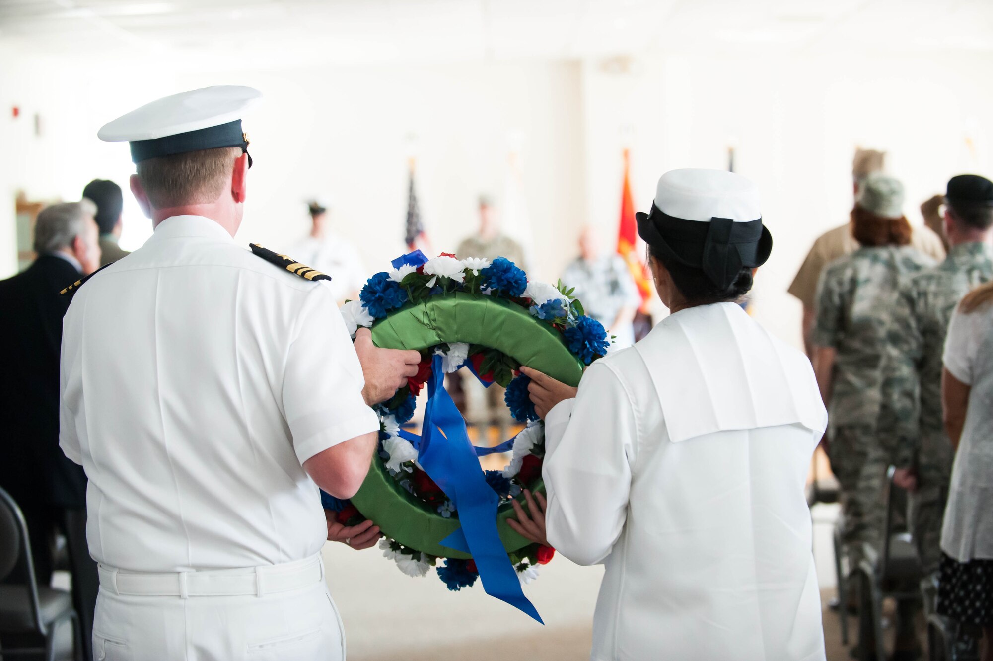 Sailors carry a commemorative wreath to the event stage at the Battle of Midway ceremony June 3, 2014, at the Flight Deck, JB MDL, N.J. The wreath was dedicated to the Sailors, Marines and Airmen who contributed to the victory against the Japanese 72 years ago. (U.S. Air Force photo by Airman 1st Class Sean M. Crowe/Released)