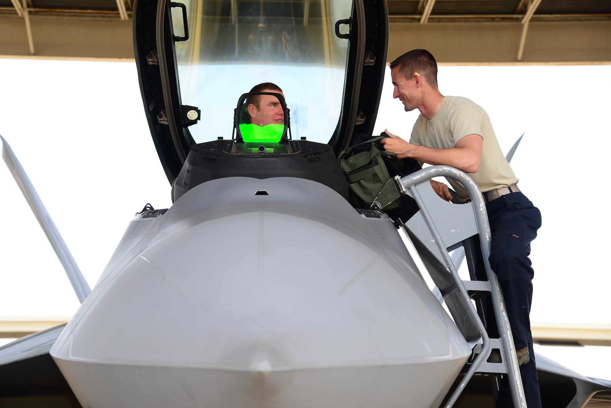 U.S. Air Force Staff Sgt. Justin Hubbard, 94th Fighter Squadron dedicated crew chief, speaks with U.S. Air Force Lt. Col. Michael Schaner, 192nd  Fighter Wing F-22 pilot to ensure all of the pre-flight checks are done properly before takeoff at Langley Air Force Base, Va., June 4, 2014. Cited for his high level of readiness and efficiency, work ethic and dedication to achieve excellence in all maintenance areas, Hubbard earned the 2013 Chief Master Sergeant of the Air Force Thomas N. Barnes Crew Chief of Year Award. (U.S. Air Force photo by Staff Sgt. Antoinette Gibson/Released)