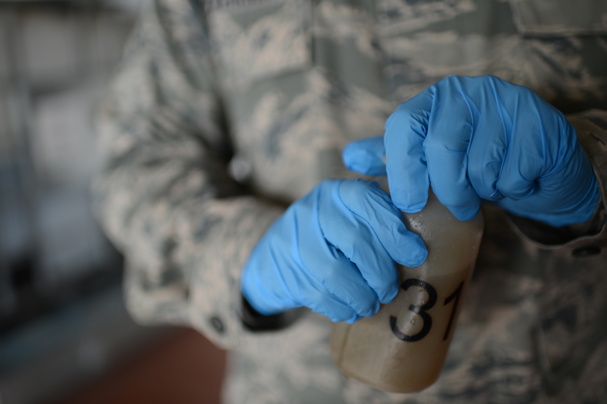 U.S. Air Force Airman 1st Class Joseph Dickerson, 52nd Civil Engineer Squadron water and fuel system maintenance technician from Oklahoma City, Okla., secures the lid of a wastewater sample at Spangdahlem Air Base, Germany, June 4, 2014. Airmen treat the water to remove possible hazardous chemicals before it is released back into the environment. (U.S. Air Force photo by Senior Airman Gustavo Castillo/Released)