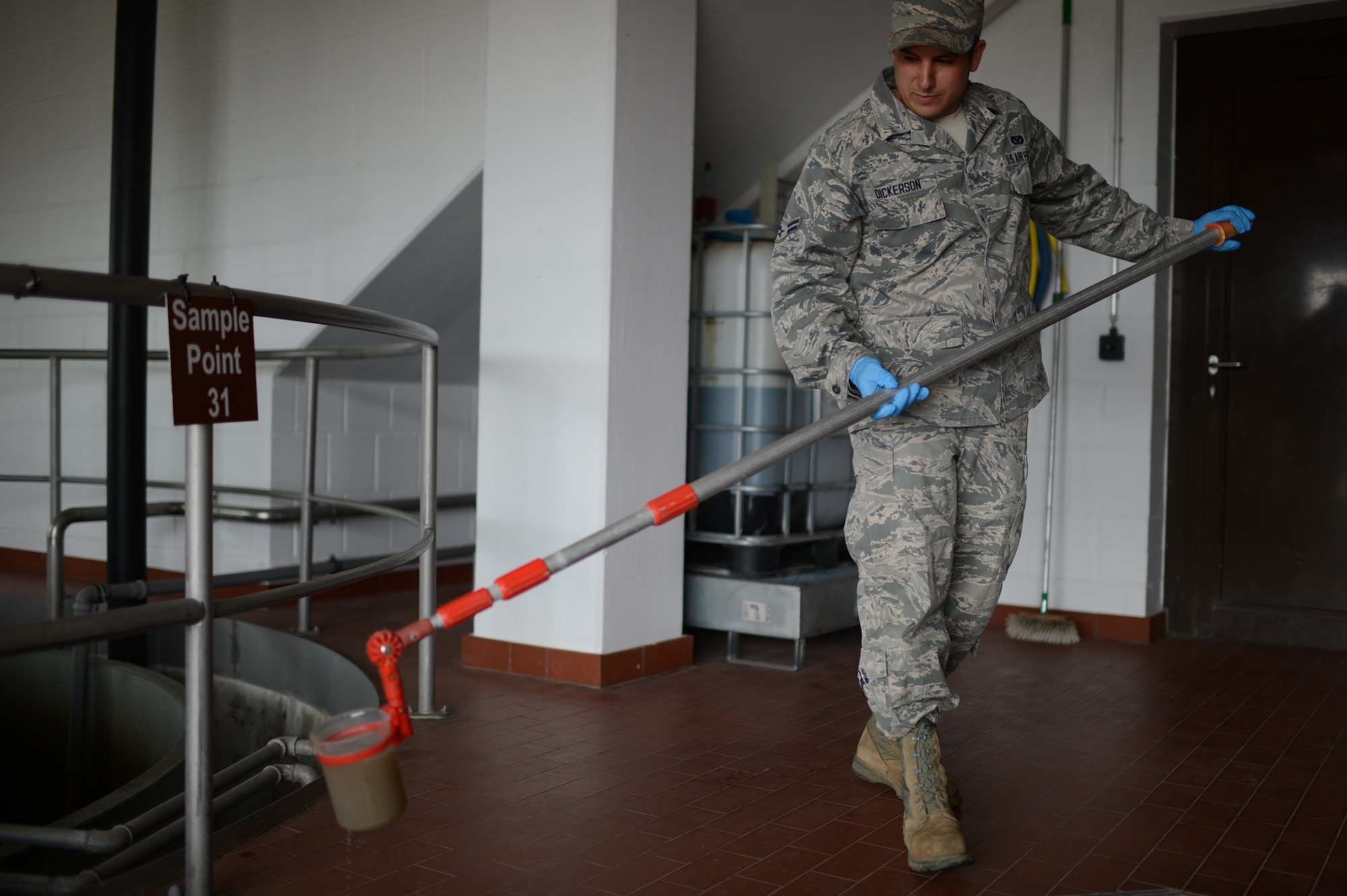 U.S. Air Force Airman 1st Class Joseph Dickerson, 52nd Civil Engineer Squadron water and fuel system maintenance technician from Oklahoma City, Okla., takes a water sample from a tank of wastewater at Spangdahlem Air Base, Germany, June 4, 2014. The water treatment facility can process approximately 2,000 cubic meters of wastewater from the base per day. (U.S. Air Force photo by Senior Airman Gustavo Castillo/Released)