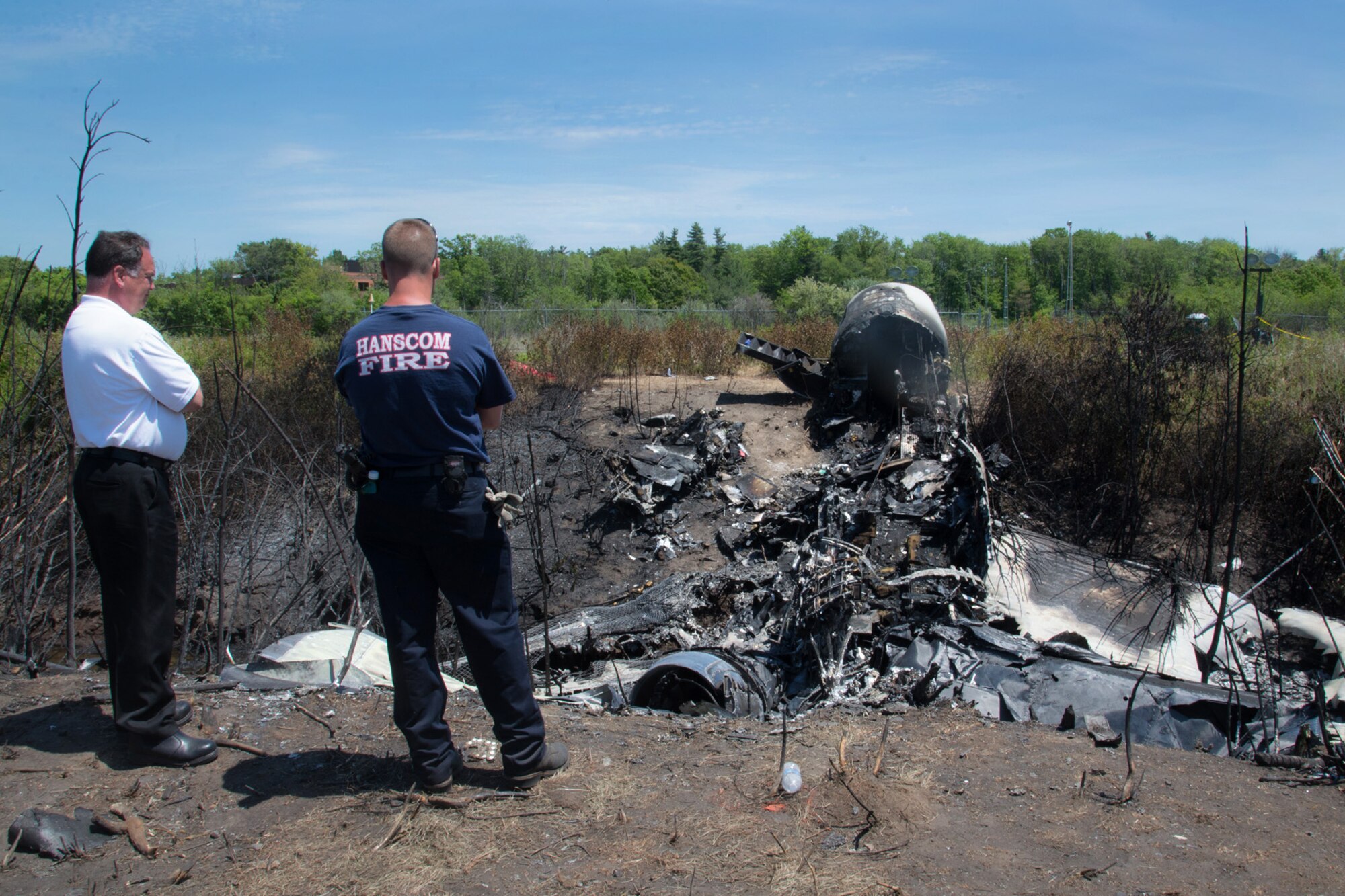 BEDFORD, Mass. -- Paul A. Seguin, 66th Civil Engineering Squadron Fire Emergency Services assistant chief of Operations, and Jerome Zuhoski, 66th CES Fire Emergency Services firefighter, look over the wreckage of a private Gulfstream IV aircraft that crashed May 31 at Hanscom Field shortly after 9:40 p.m., leaving all seven people onboard dead. All 12 Hanscom firefighters on duty responded to the crash seconds after the Air Traffic Control tower activated the crash network to alert the Hanscom Fire Station of the incident. In addition to Hanscom, firefighters from Bedford, Lexington, Lincoln, Concord and Waltham were all involved in the response. (U.S. Air Force photo by Walter Santos)