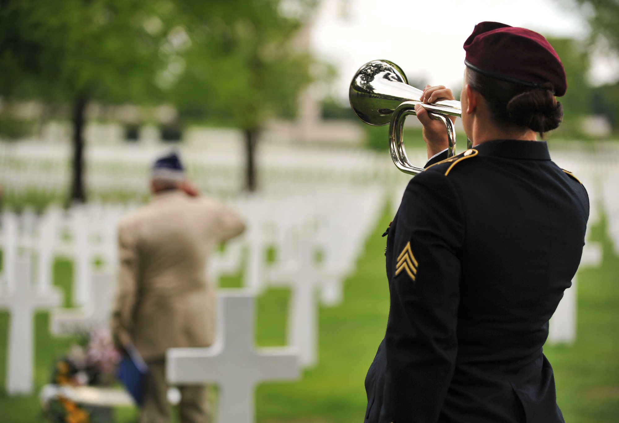Leslie Cruise, a World War II veteran, salutes the grave of Pvt. Richard Vargas while Army Sgt. Jeannette Mason, 5th Quartermaster Theater Aerial Delivery Company parachute rigger, plays taps during a wreath laying ceremony at Lorraine American National Cemetery and Memorial, St. Avold, France, June 2, 2014. Seventy years ago on June 7, 1944 Pvt. Richard Vargas saved Cruise’s life during the invasion of Normandy. Cruise went to France several times prior to this visit looking for his friend’s grave in order to say thank you. (U.S. Air Force photo/Senior Airman Hailey Haux)