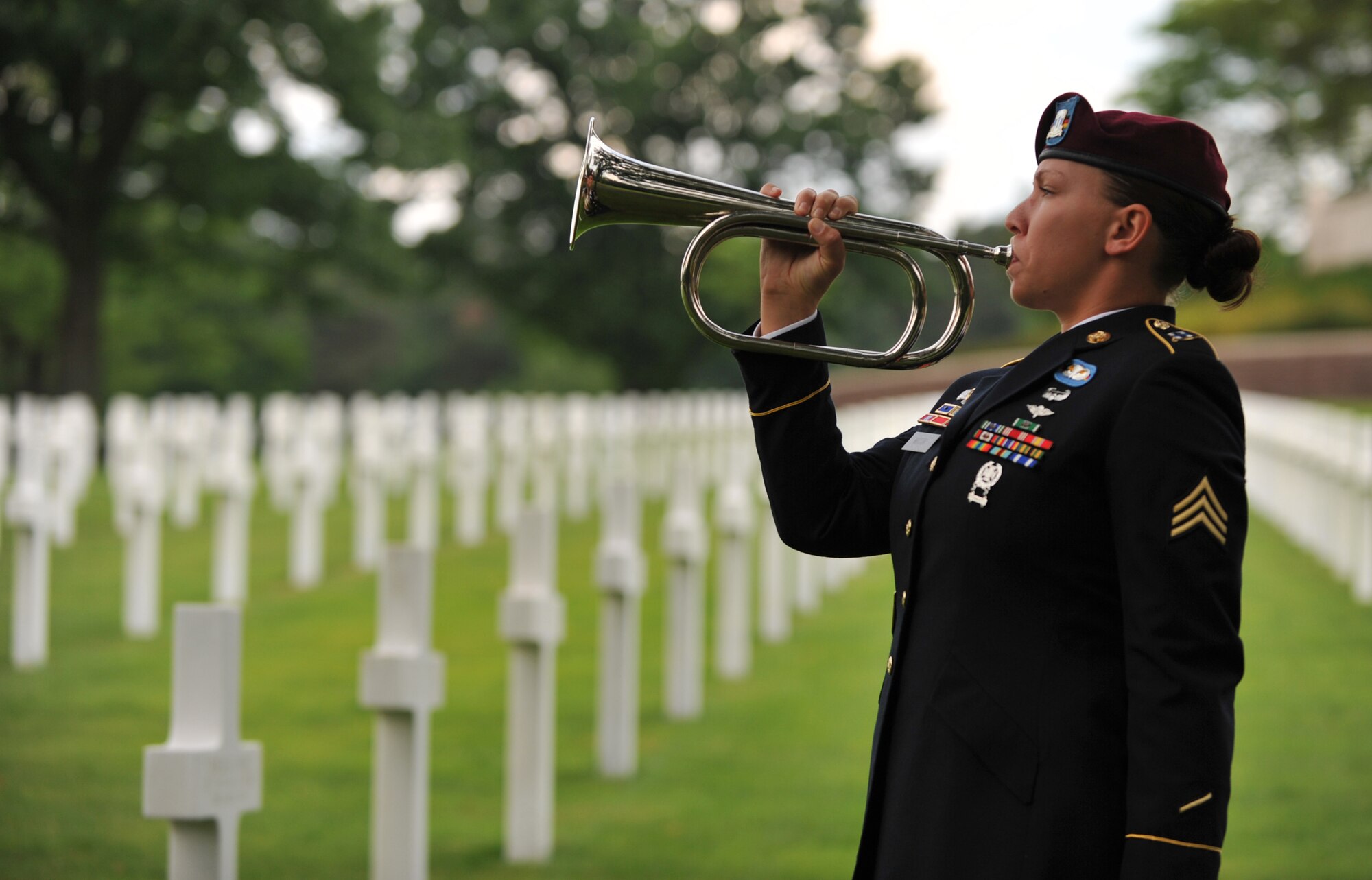 Army Sgt. Jeannette Mason, 5th Quartermaster Theater Aerial Delivery Company parachute rigger, plays taps during a wreath laying ceremony at Lorraine American National Cemetery and Memorial, St. Avold, France, June 2, 2014. Seventy years ago on June 7, 1944 Pvt. Richard Vargas saved Leslie Cruise’s life, a World War II veteran, during the invasion of Normandy. Cruise went to France several times prior to this visit looking for his friend’s grave in order to say thank you. (U.S. Air Force photo/Senior Airman Hailey Haux)