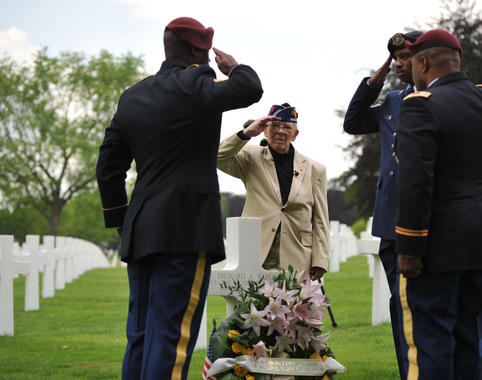 Leslie Cruise, a World War II veteran, and members from the 5th Quartermaster Theater Aerial Delivery Company, 435th Air Ground Operations Wing’s Contingency Response Group and 21st Theater Sustainment Command salute the grave of Pvt. Richard Vargas at Lorraine American National Cemetery and Memorial, St. Avold, France, June 2, 2014. Seventy years ago on June 7, 1944 Pvt. Richard Vargas saved Cruise’s life during the invasion of Normandy. Cruise went to France several times prior to this visit looking for his friend’s grave in order to say thank you.  (U.S. Air Force photo/Senior Airman Hailey Haux)