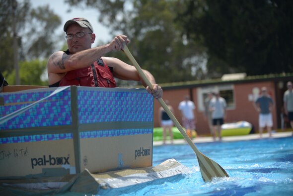 Staff Sgt. Luke Maynard, 39th Maintenance Squadron aircraft electrical and environment system craftsman, rows his cardboard boat towards the finish-line May 29, 2014, Incirlik Air Base, Turkey. Airmen from the 39th MXS teamed up to create boats out of cardboard and duct tape to race against each other at the base pool.  (U.S. Air Force photo by Senior Airman Nicole Sikorski/Released) 
